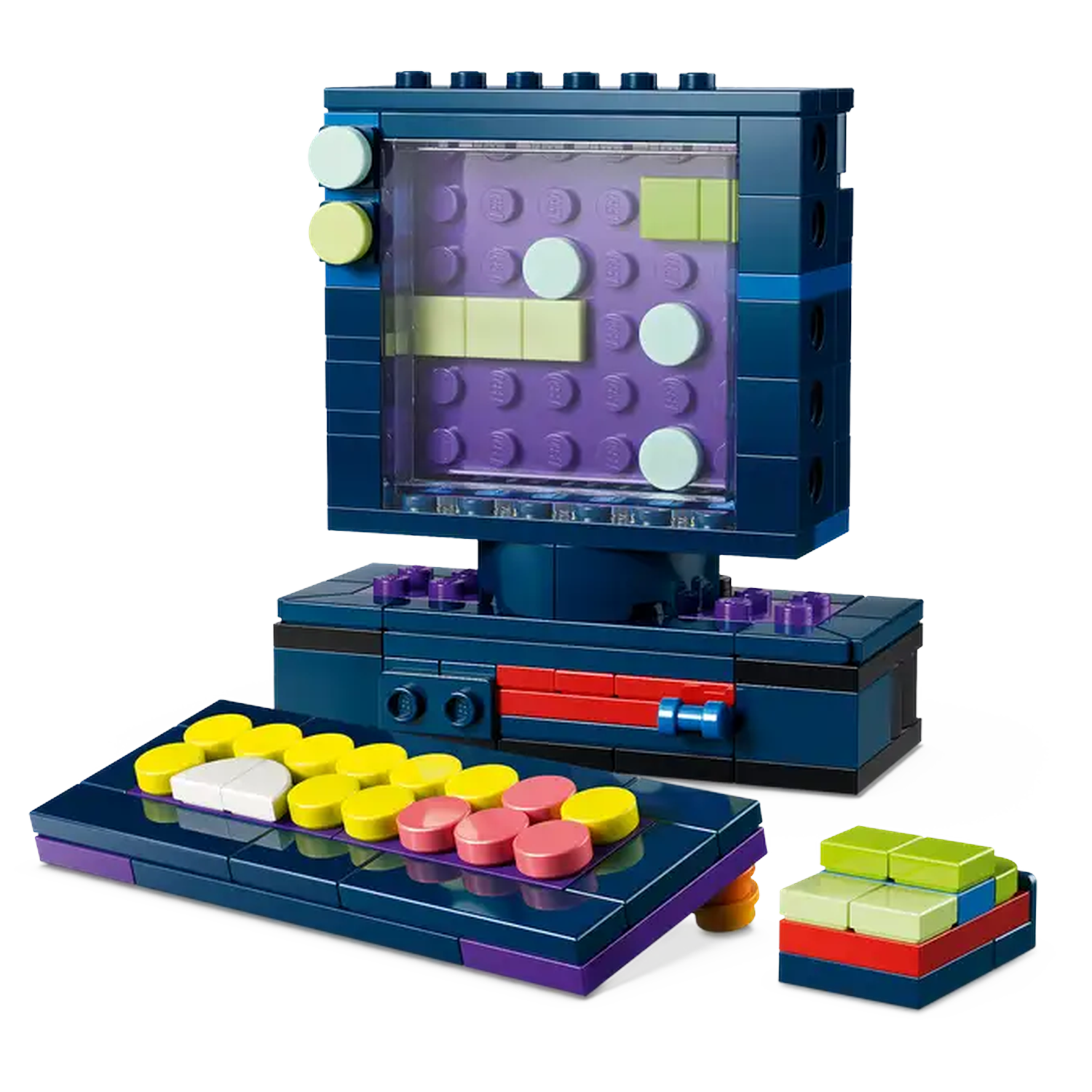A Lego model of a retro computer, including a screen with colorful blocks and a keyboard. A small stack of blocks is next to it.