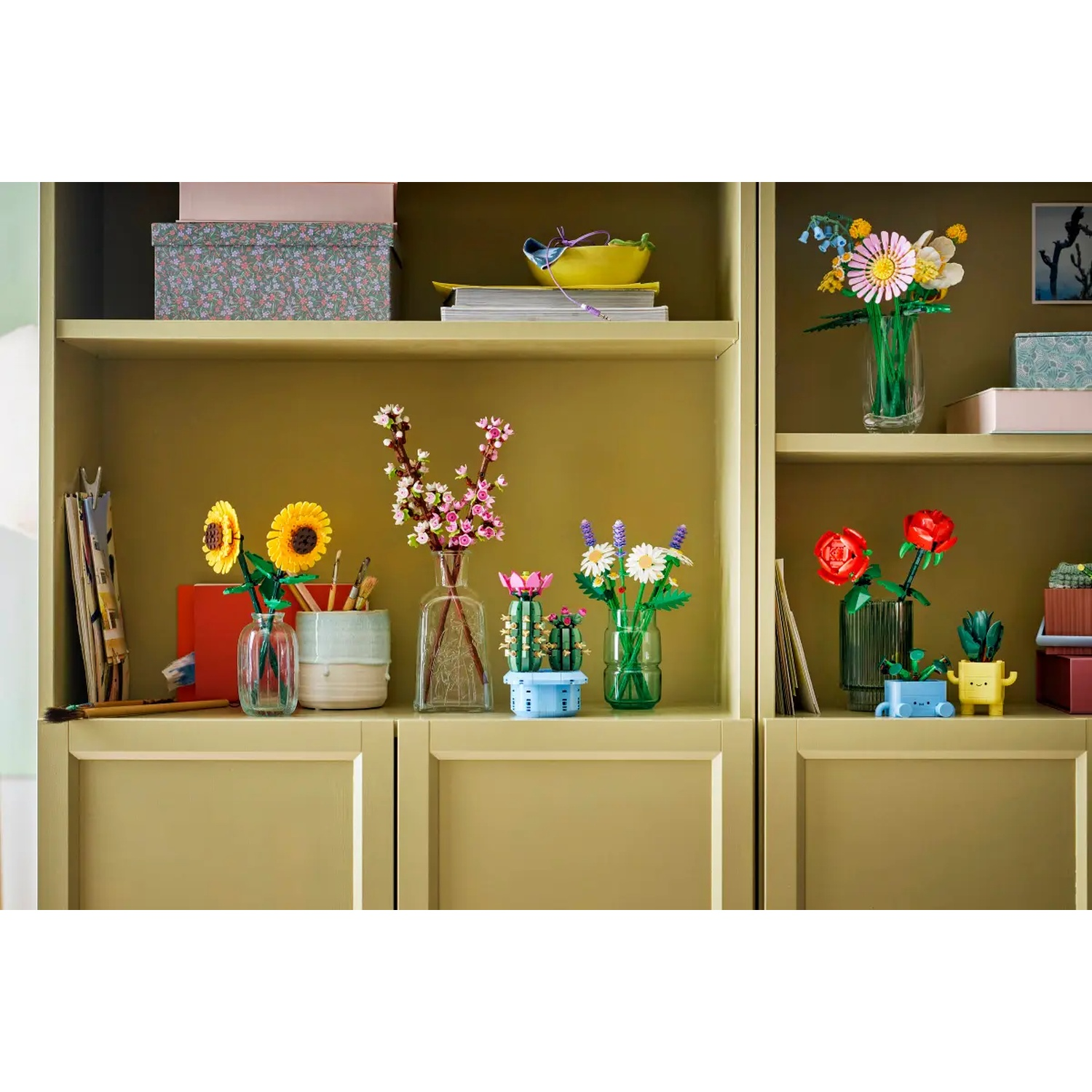 Étagère avec des fleurs Lego dans des vases. Des tournesols, des roses et d'autres compositions florales sont exposés sur une étagère moutarde.