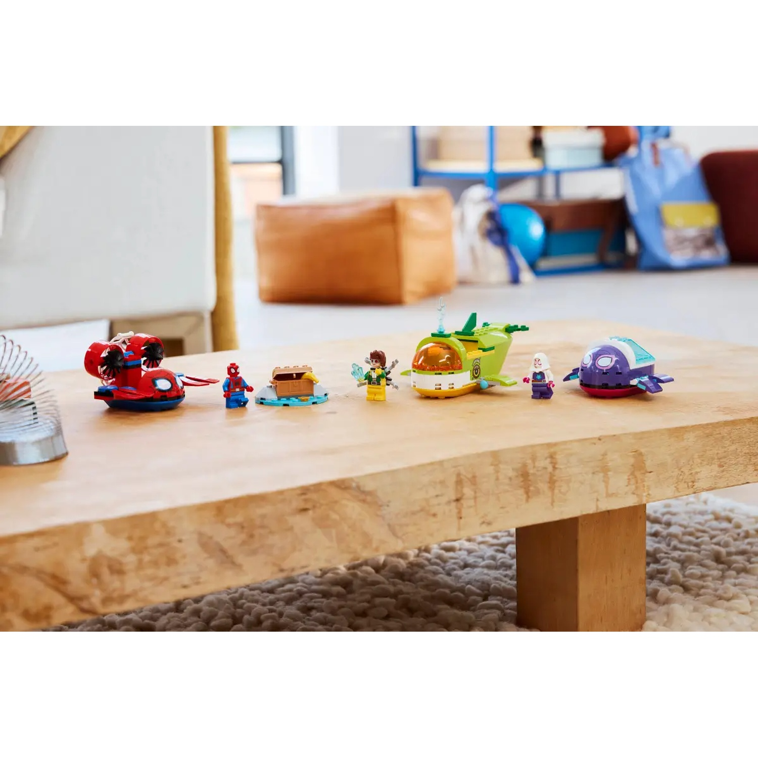 Une table en bois présente des ensembles Lego de différentes couleurs et designs, dont Spider-Man et des véhicules sous-marins, sur un fond flou.
