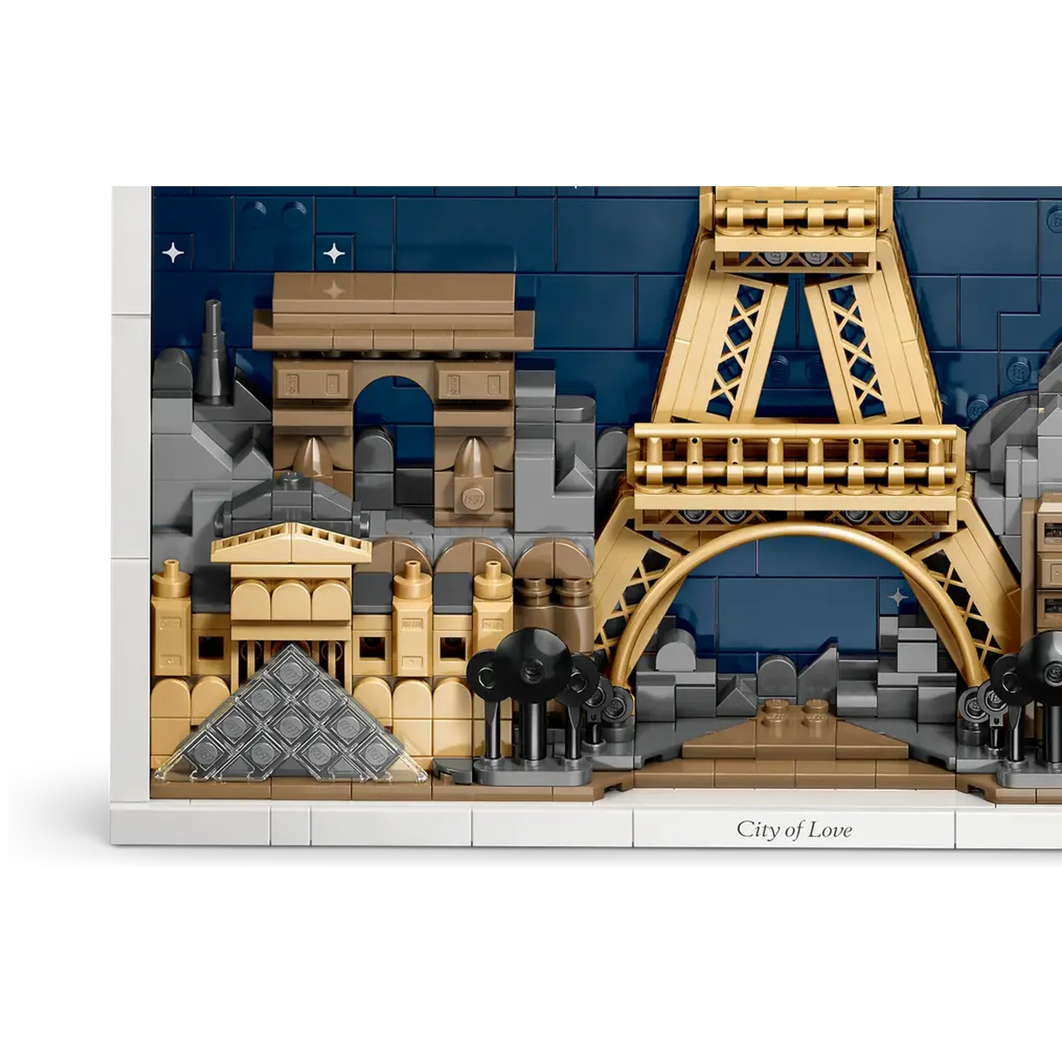 A Lego model of Paris featuring the Eiffel Tower, Arc de Triomphe, and Louvre Pyramid, with a dark blue night sky backdrop.