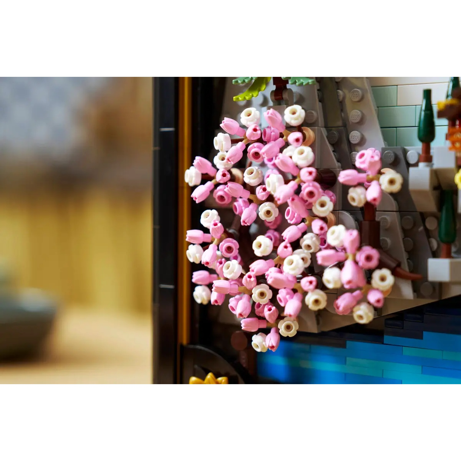 Lego scene with pink and white cherry blossoms. In the background are rock formations and water. The scene is framed in black.