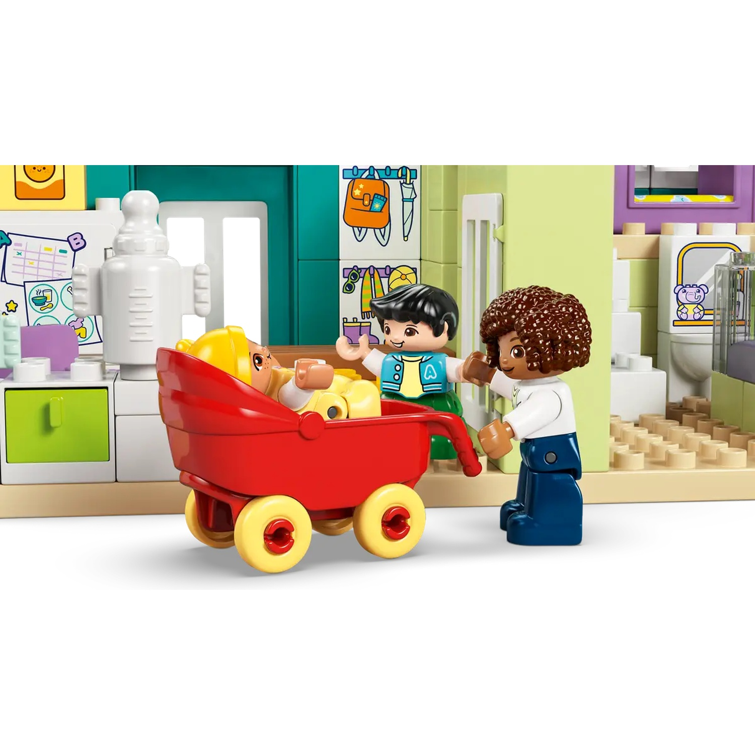 Ensemble Lego avec trois figurines et un bébé dans une poussette rouge. L'arrière-plan comprend une cuisine et une salle de bain.