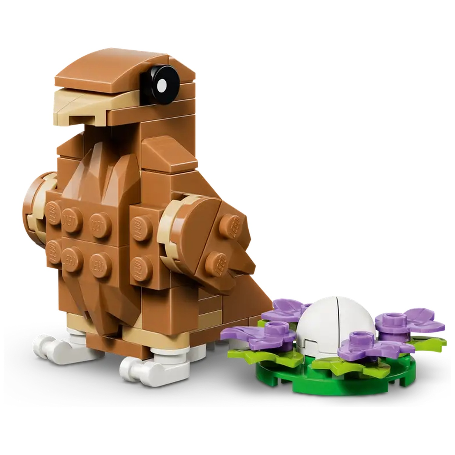 Een bruine Lego vogel, met een zwart oog. Daarnaast een nest met een wit ei, omringd door paarse en groene bloemen.