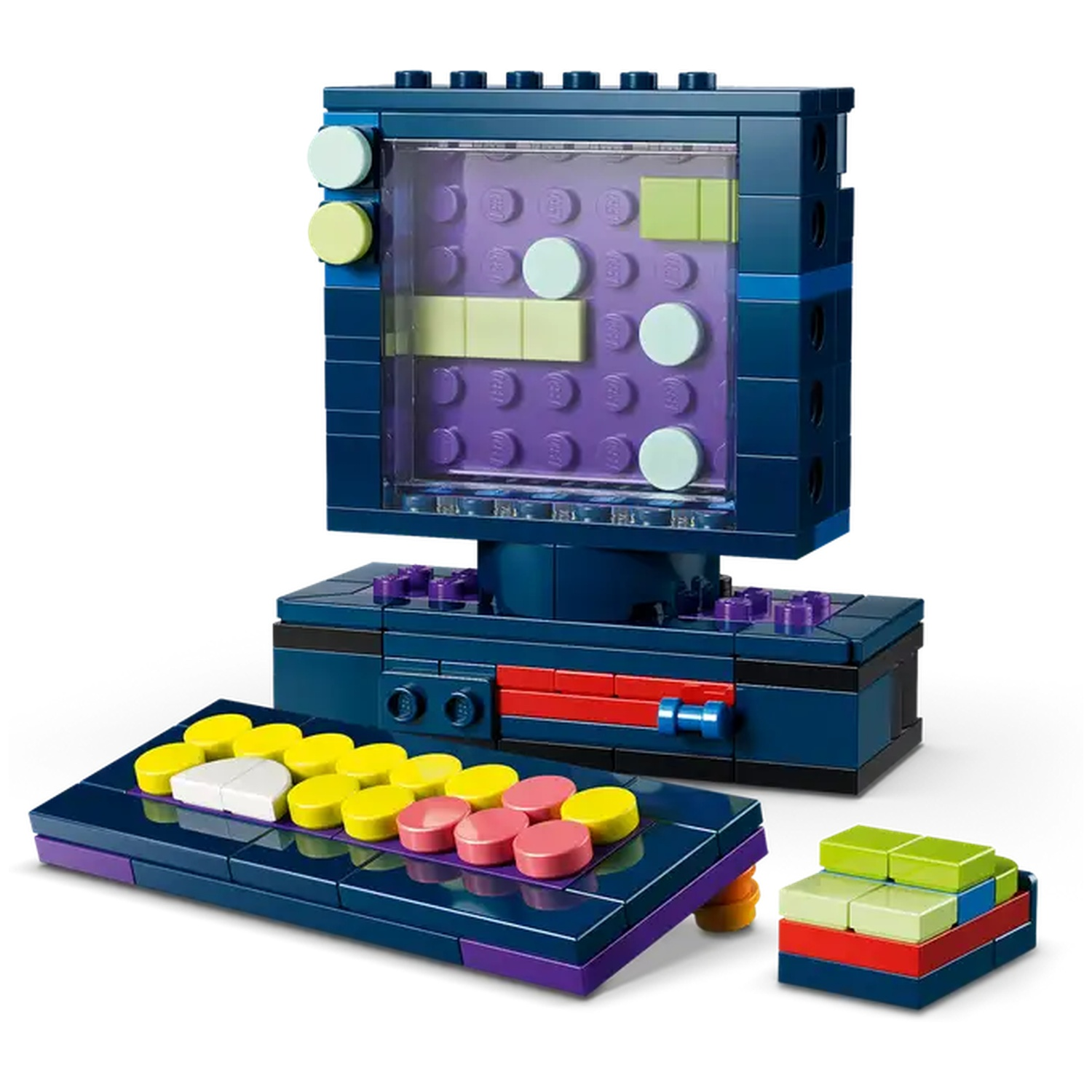A Lego model of a retro computer and controller. The screen displays shapes. Keyboard with colorful buttons. Additional block structure.