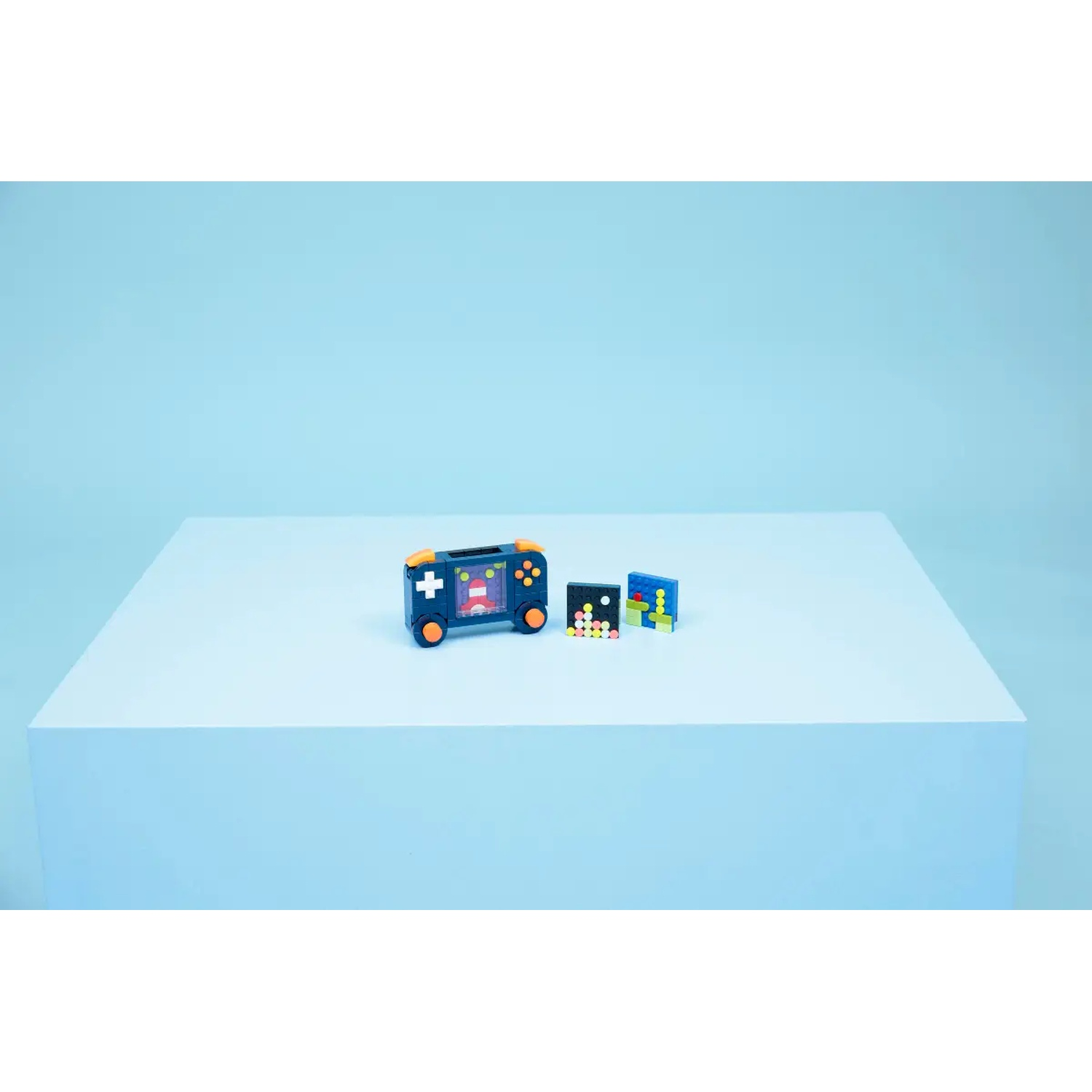 A toy video game with orange accents, two game cartridges, and a light blue background.