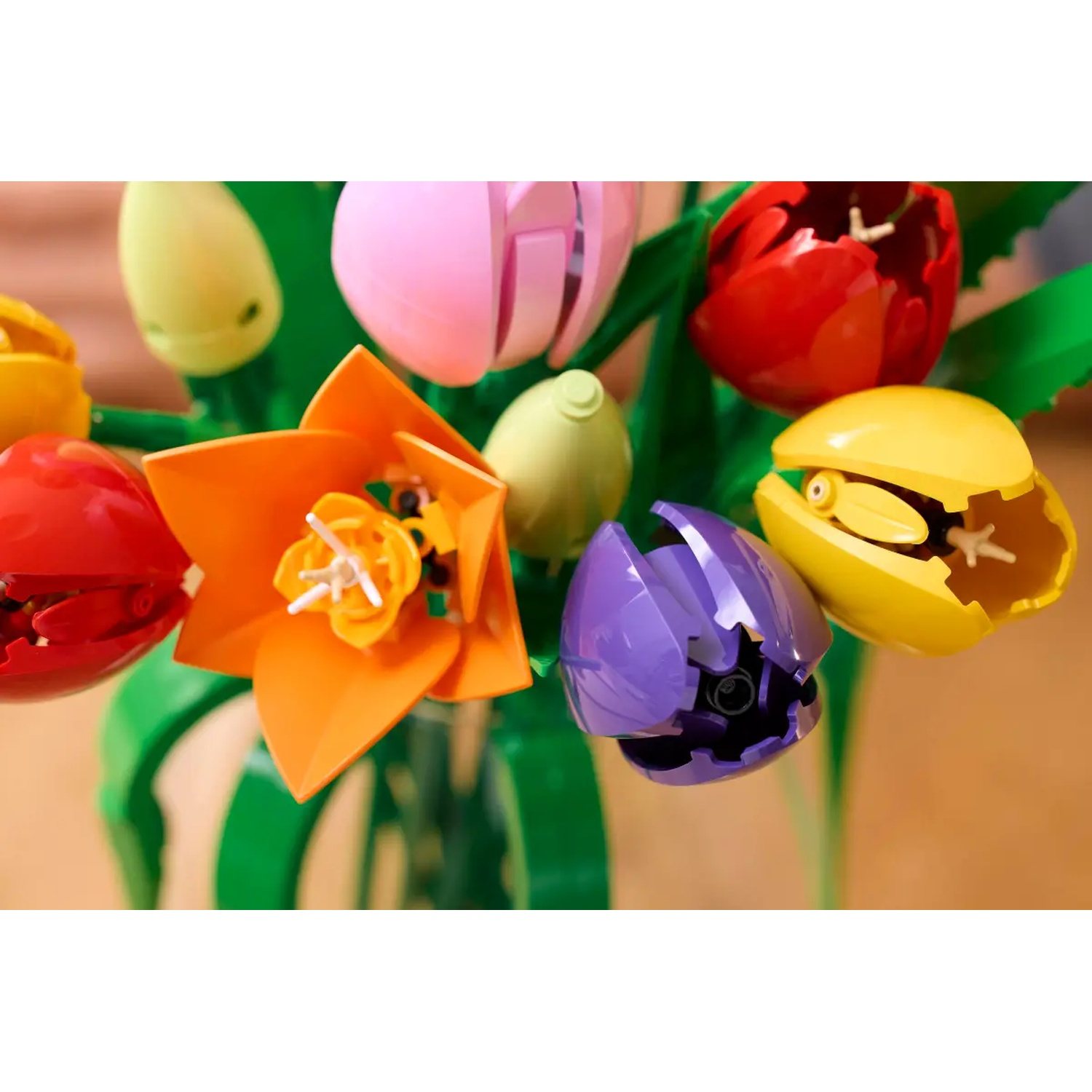 Close-up van een boeket kleurrijke tulpenbloemen van plastic. De kleuren zijn rood, geel, oranje, roze en paars.