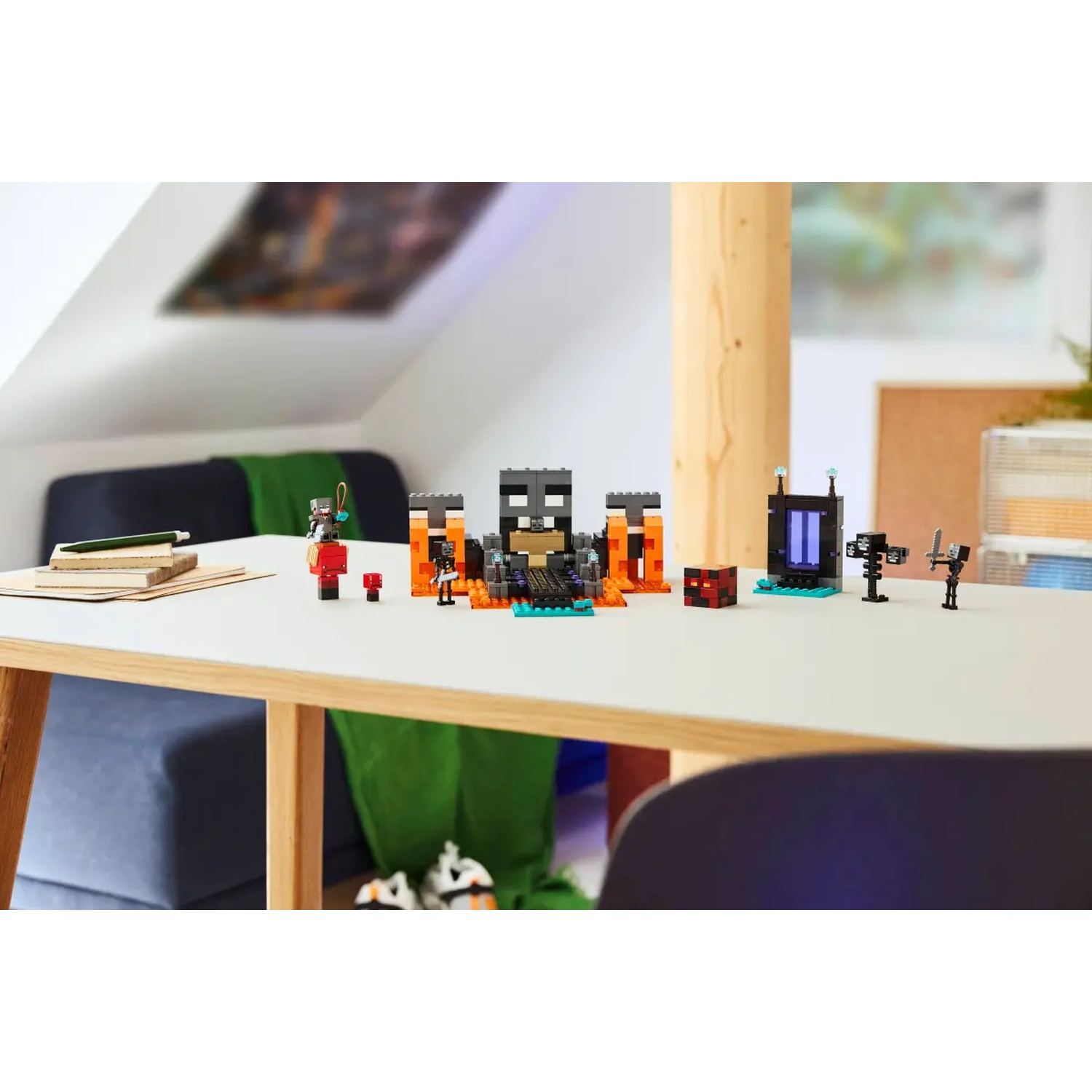 Un ensemble Lego Minecraft sur une table blanche. Il présente des personnages, des structures et un portail d'obsidienne. L'arrière-plan a un canapé et une fenêtre.