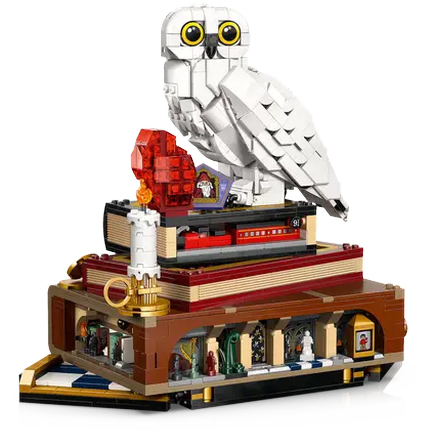 A Lego set featuring a white owl, books, and miniature figures. A candle and a red object sit on the books.