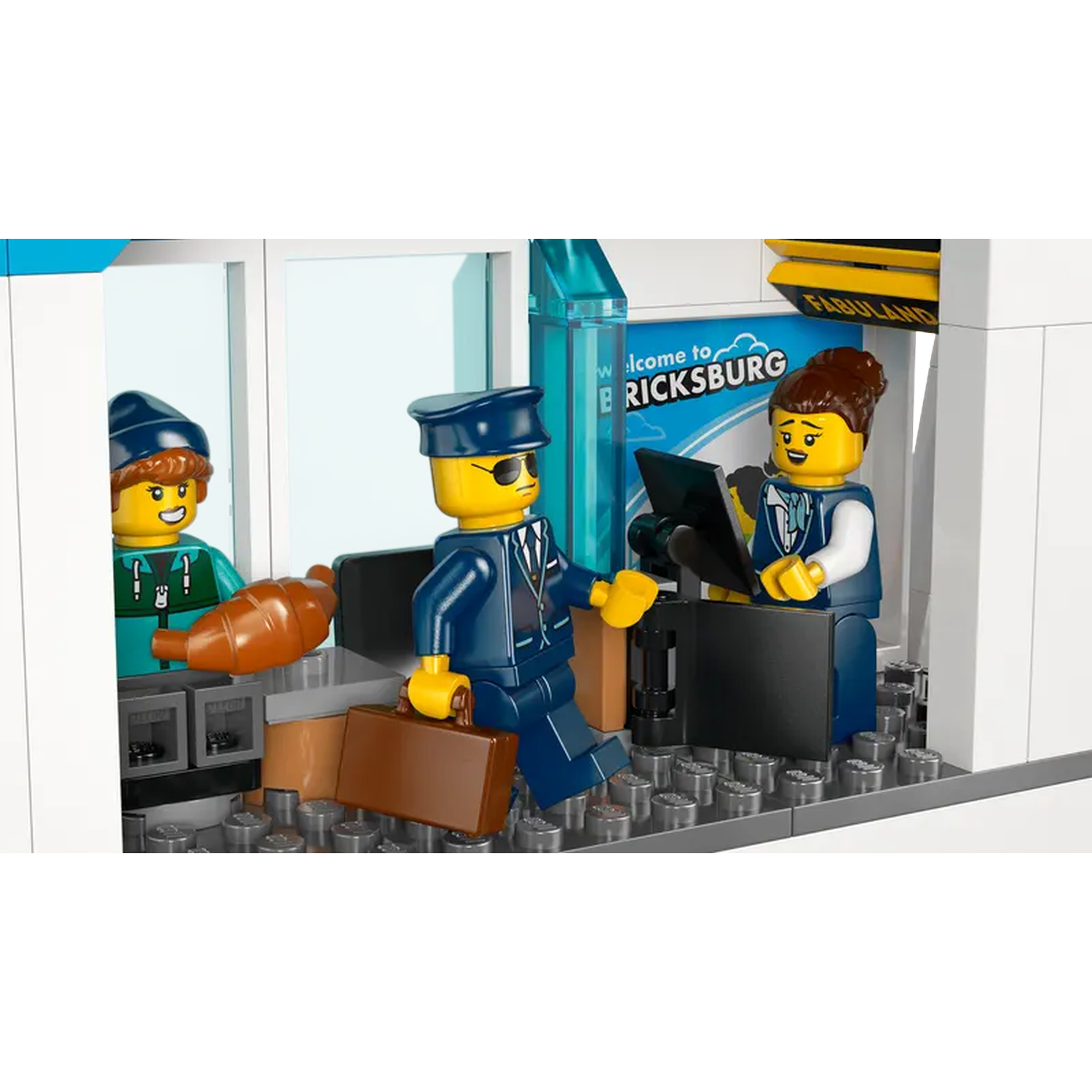 Lego scene at the airport. Three Lego figures, one with a suitcase, welcome sign, and a person holding a croissant.