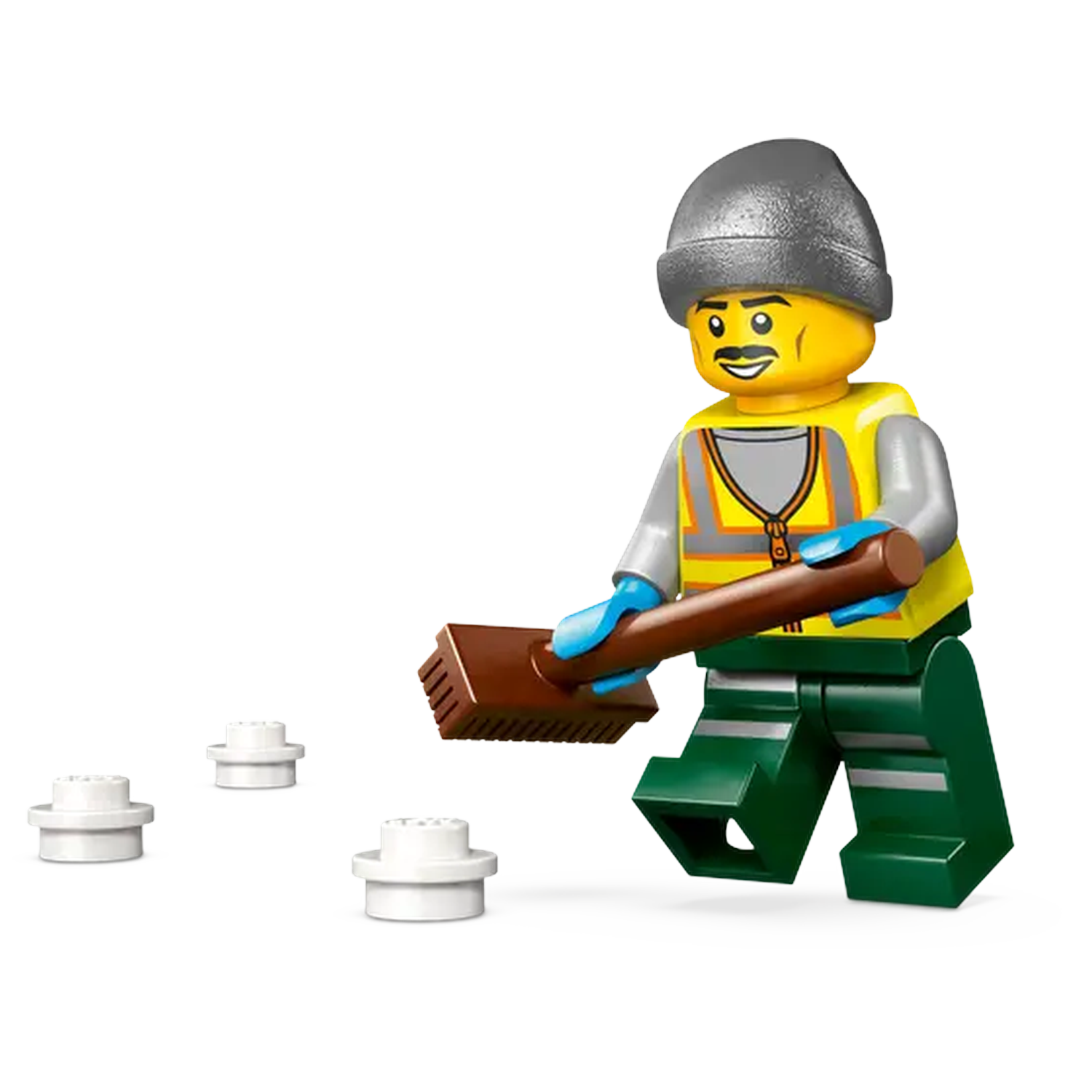 A Lego figure of a street cleaner with a broom, wearing a hat, vest and green pants. There are three white Lego pieces on the ground.