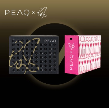 Dwa pudełka, jedno czarne ze złotym wzorem, drugie różowe z białymi sercami. Widoczne logo PEAQ i podpis.