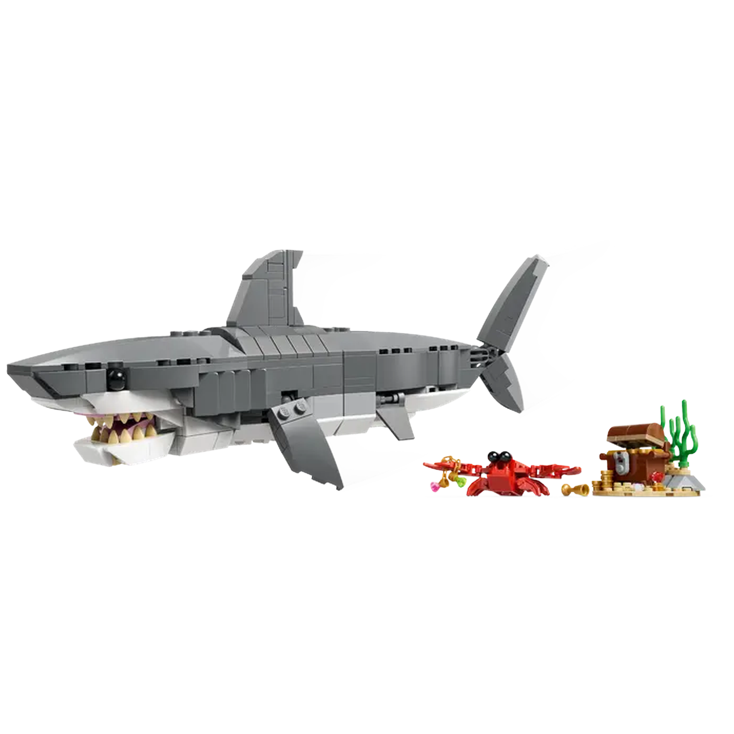 A Lego shark with open jaws swims past a crab holding jewels and a treasure chest on a small island.