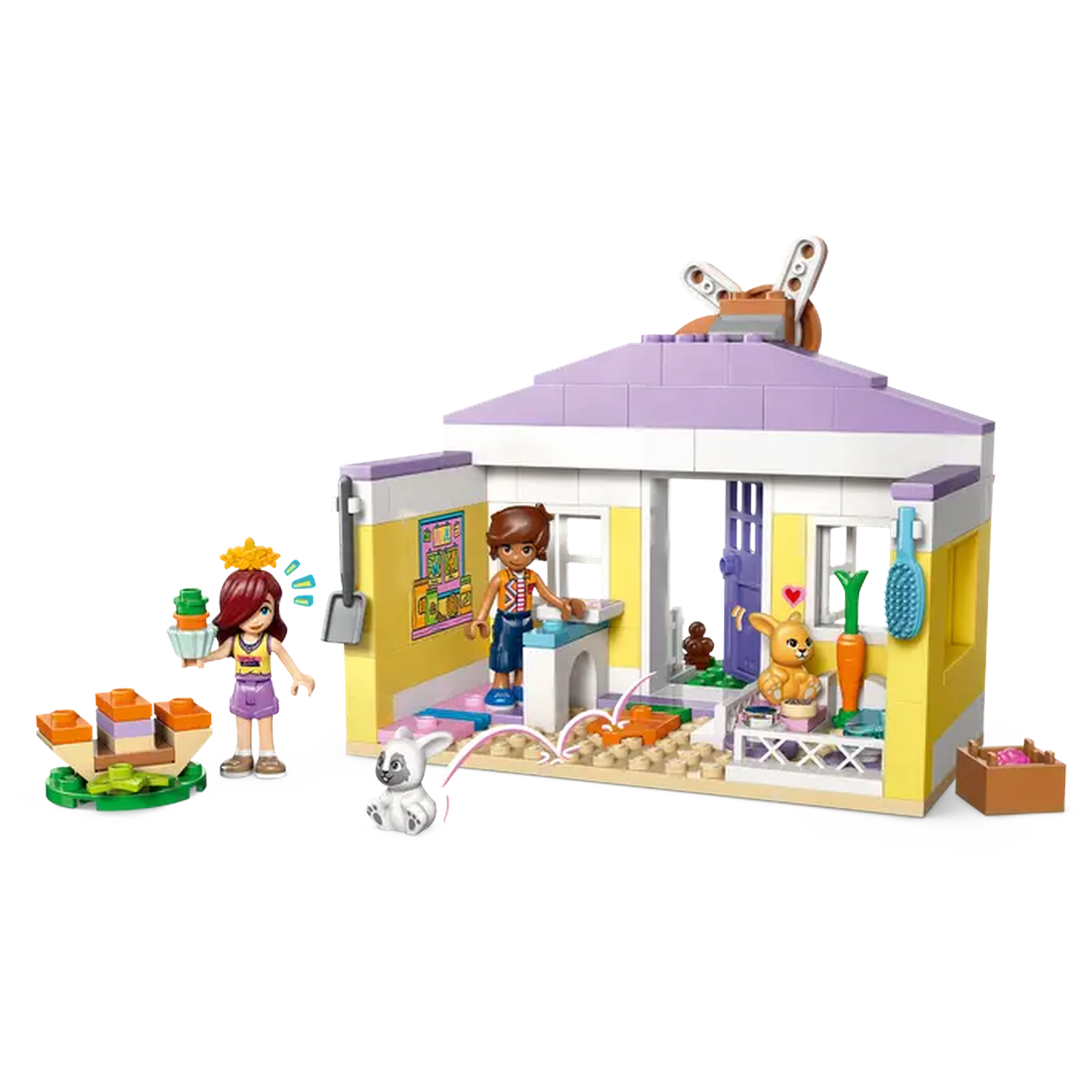 Lego set with house, figures, and animals. A girl holds a cake. Another figure stands in the house. A bunny and a dog are present.