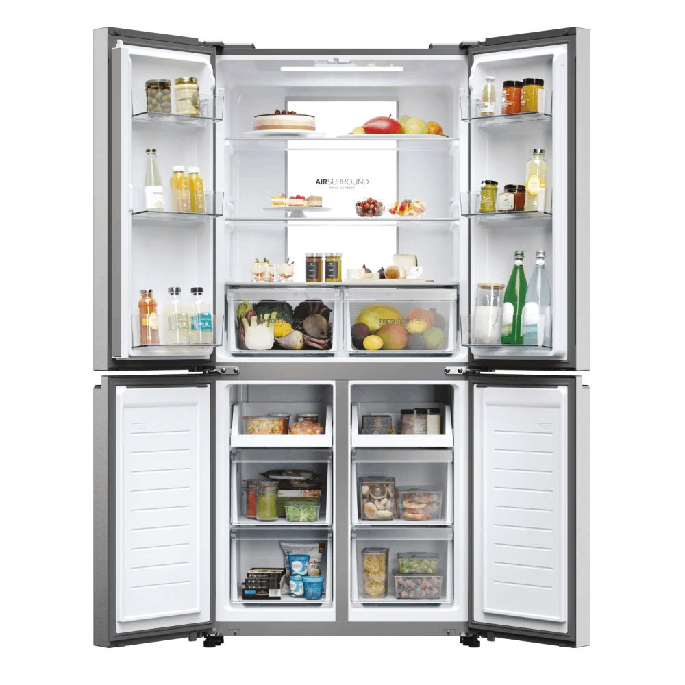 Refrigerador abierto lleno de comida: frutas, verduras, bebidas y frascos. Congelador abajo. Las puertas están abiertas.