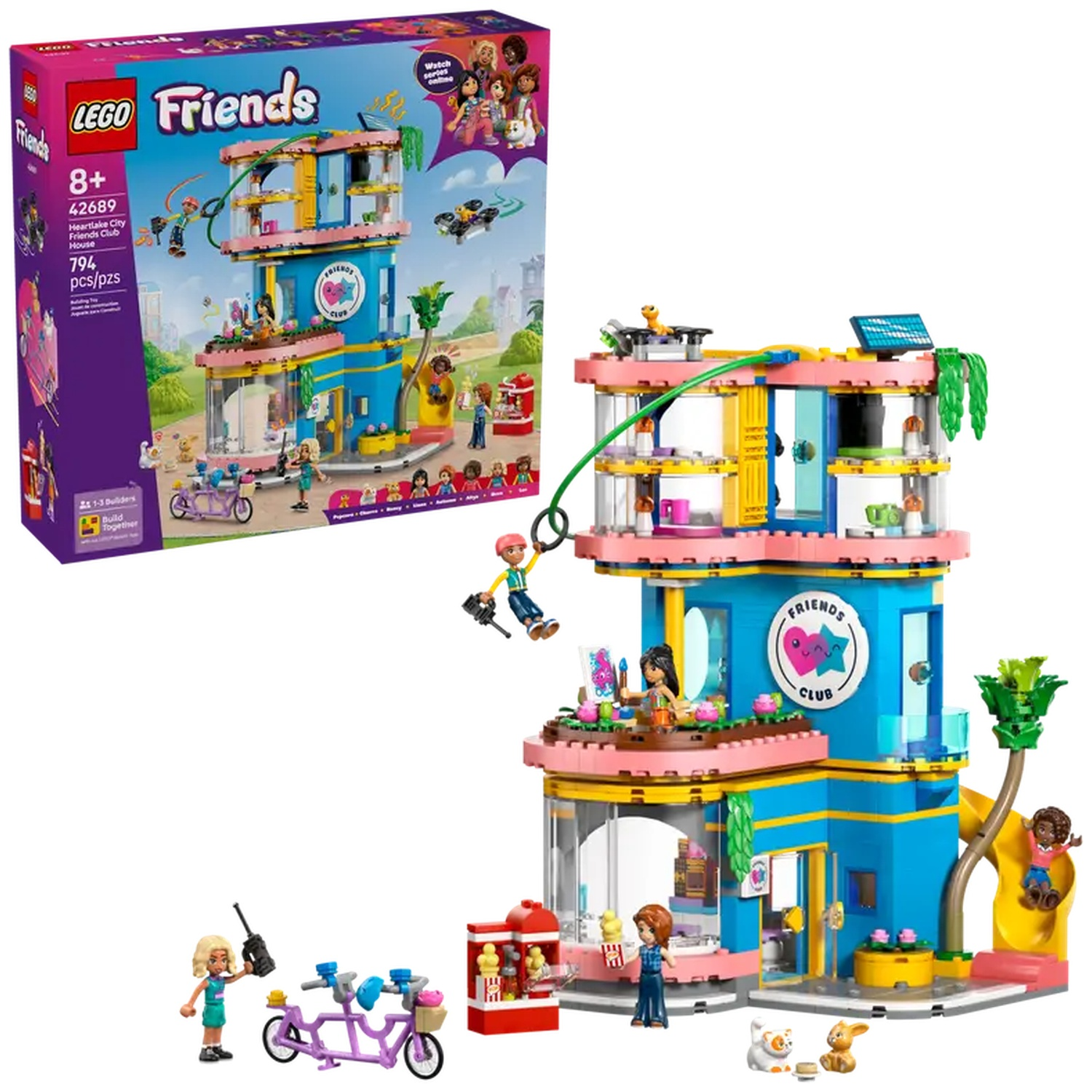 Lego Friends set with a blue and pink building, figures, a tandem bike, ice cream stand, and a slide.