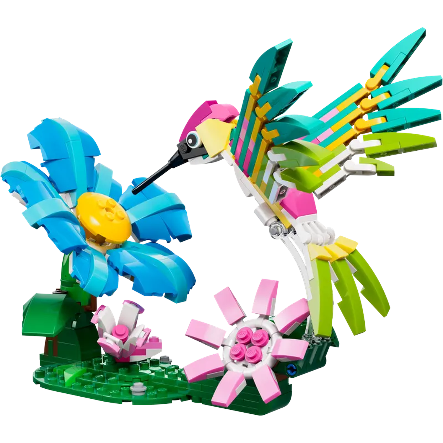 Un colibri Lego vole près de fleurs Lego bleues et roses. La scène se déroule sur une base Lego verte.