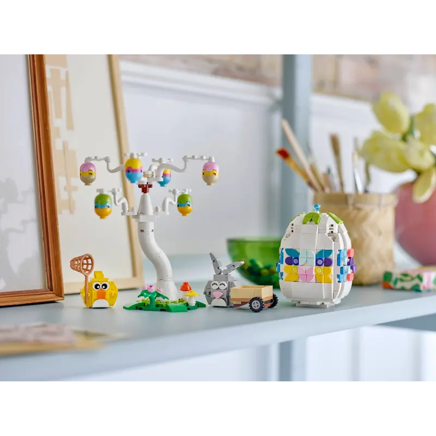 Scène de Pâques Lego. Comprend un arbre avec des œufs de Pâques, un poussin, un lapin avec une charrette et une structure en forme d'œuf.