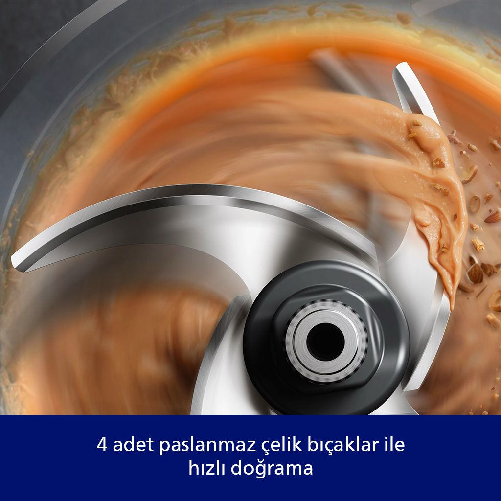 Gıda işlemcisinde paslanmaz çelik bıçaklar fındıkları ve kremsi bir maddeyi doğruyor. Bıçaklar metalik, arka plan bulanık.