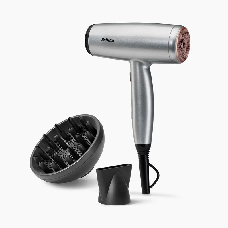 Un secador de pelo Babyliss plateado con boquilla rosa, difusor negro y boquilla negra sobre fondo blanco.