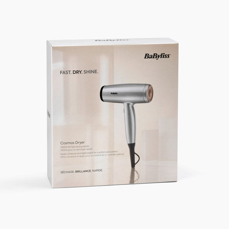 Un secador de pelo plateado Babyliss Cosmos está en su caja. La caja tiene texto: Rápido. Seco. Brillo. y otros detalles.