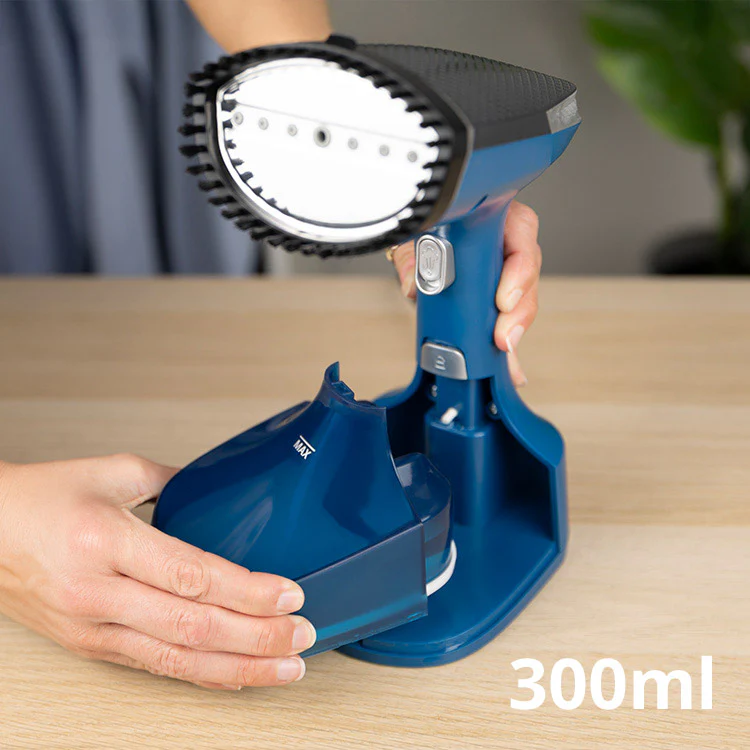 Una persona ensamblando un vaporizador de mano azul. El tanque de agua se coloca en la base. El dispositivo está sobre una superficie de madera.