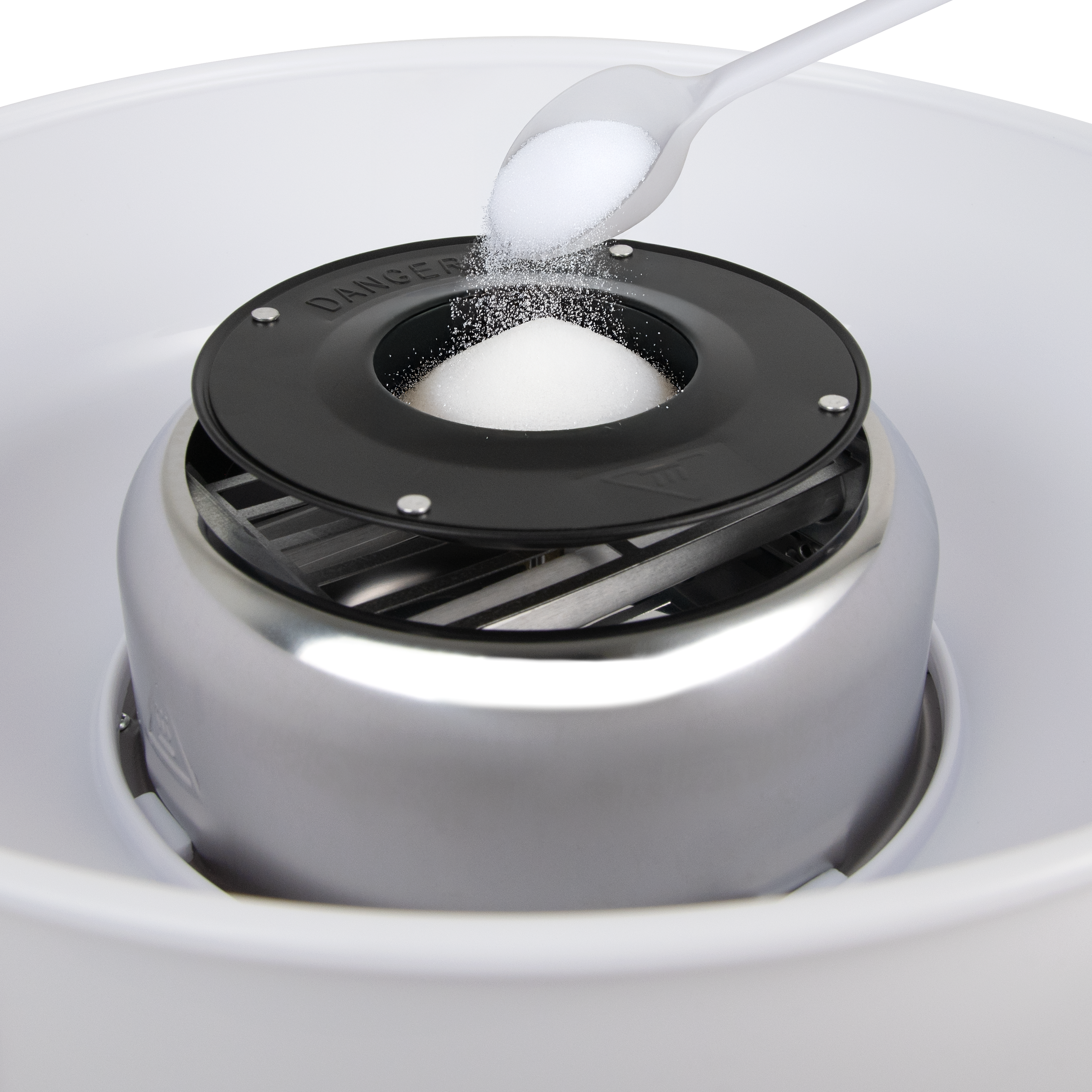 Maszyna do waty cukrowej z wsypywanym cukrem. Maszyna jest srebrna i czarna, z białą miską.