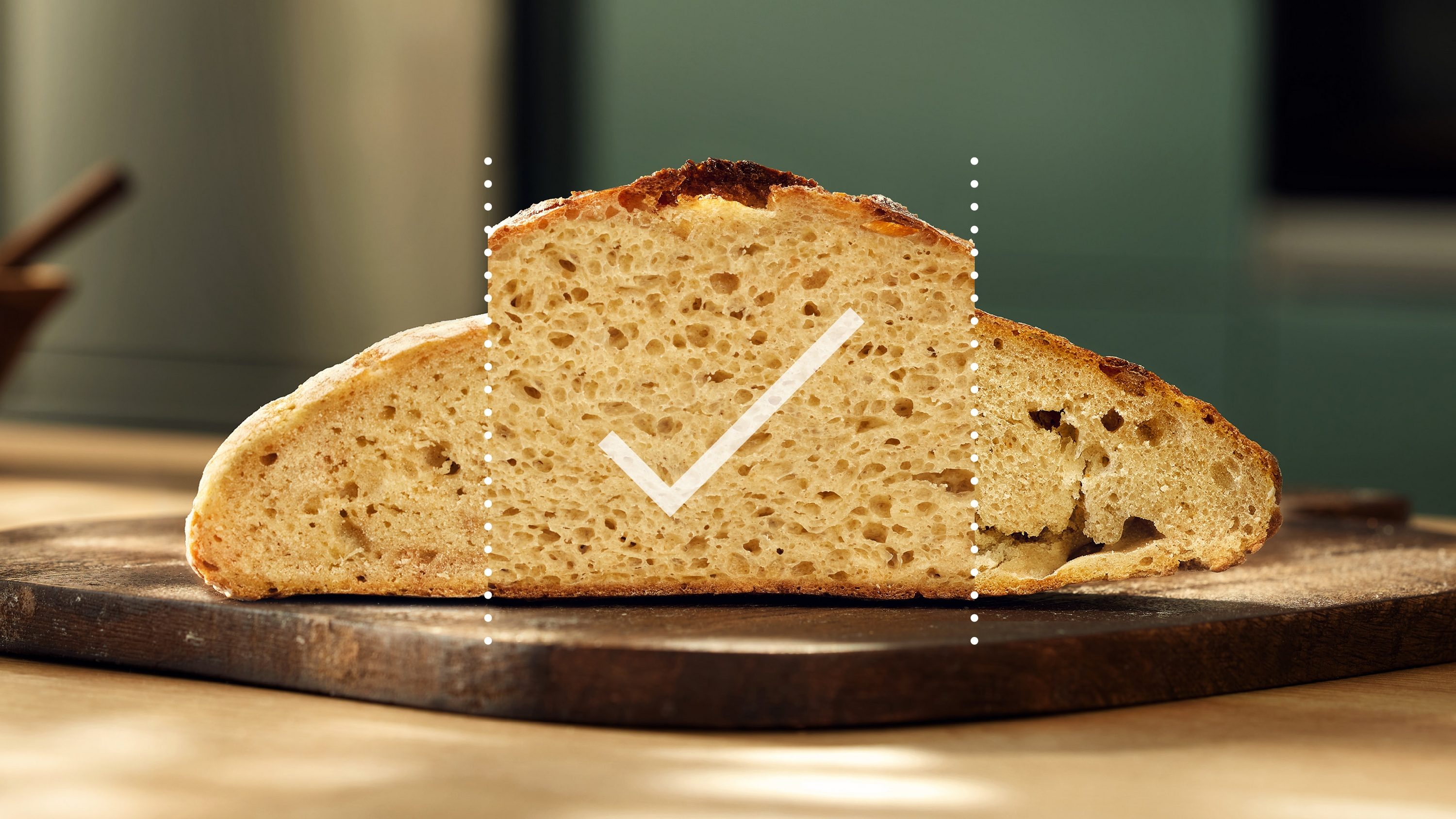 Kawałek chleba ze znakiem wyboru na drewnianej desce. Chleb jest jasno brązowy z wieloma dziurami.