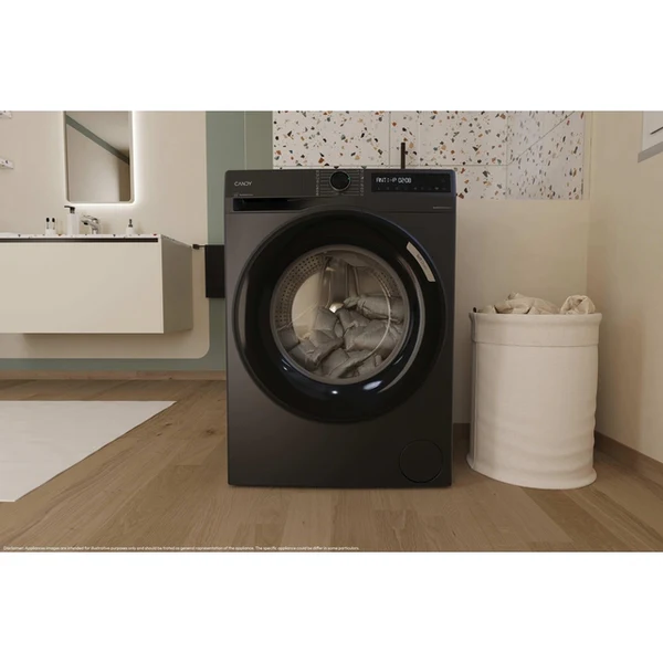 Una lavadora negra con ropa dentro está en un baño. También se ven una cesta de lavandería blanca y otros accesorios de baño.