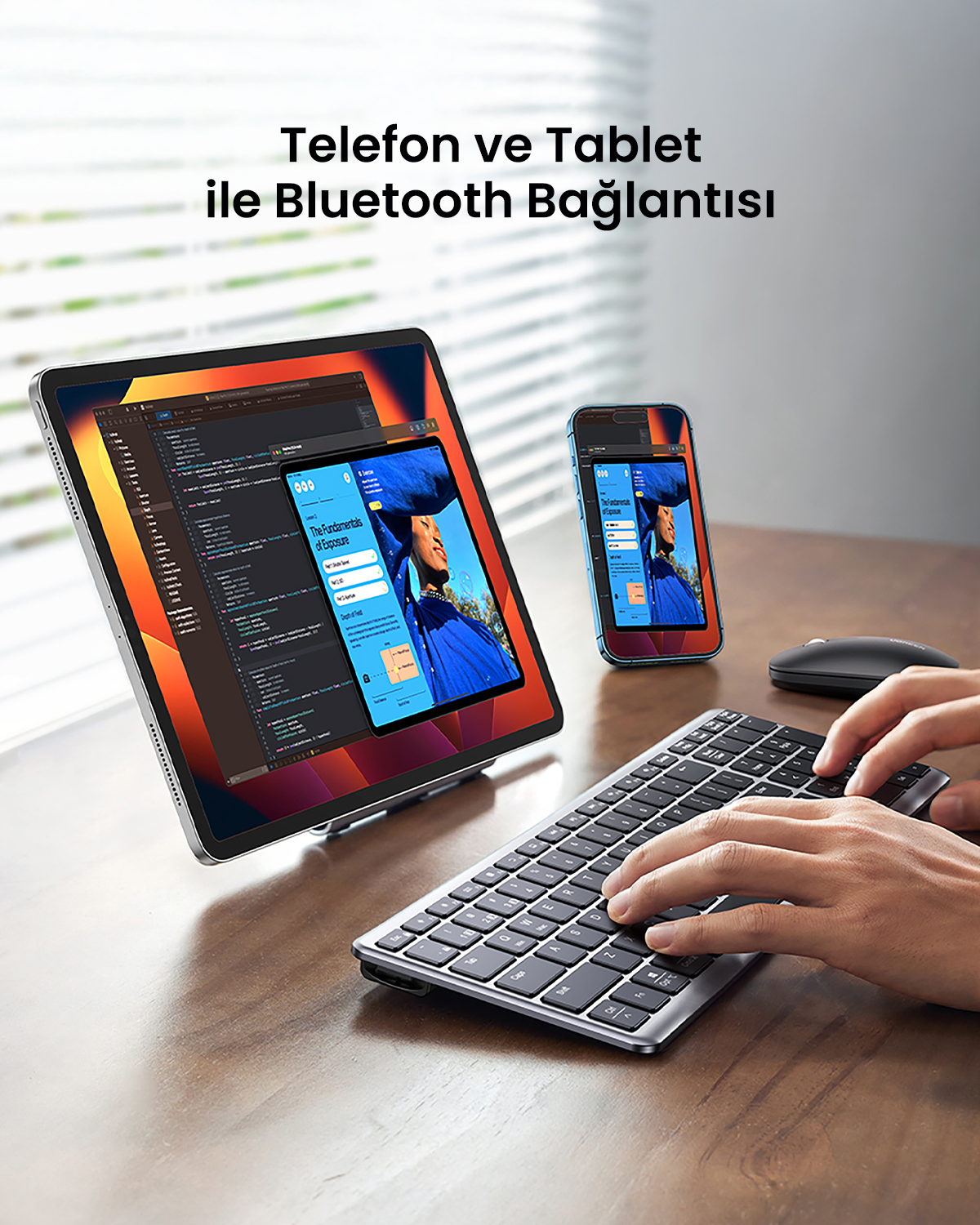 Bluetooth ile bağlı tablet ve telefon, klavye ve fare ile. Ekranlar web sayfaları gösteriyor. Eller klavyede yazıyor.
