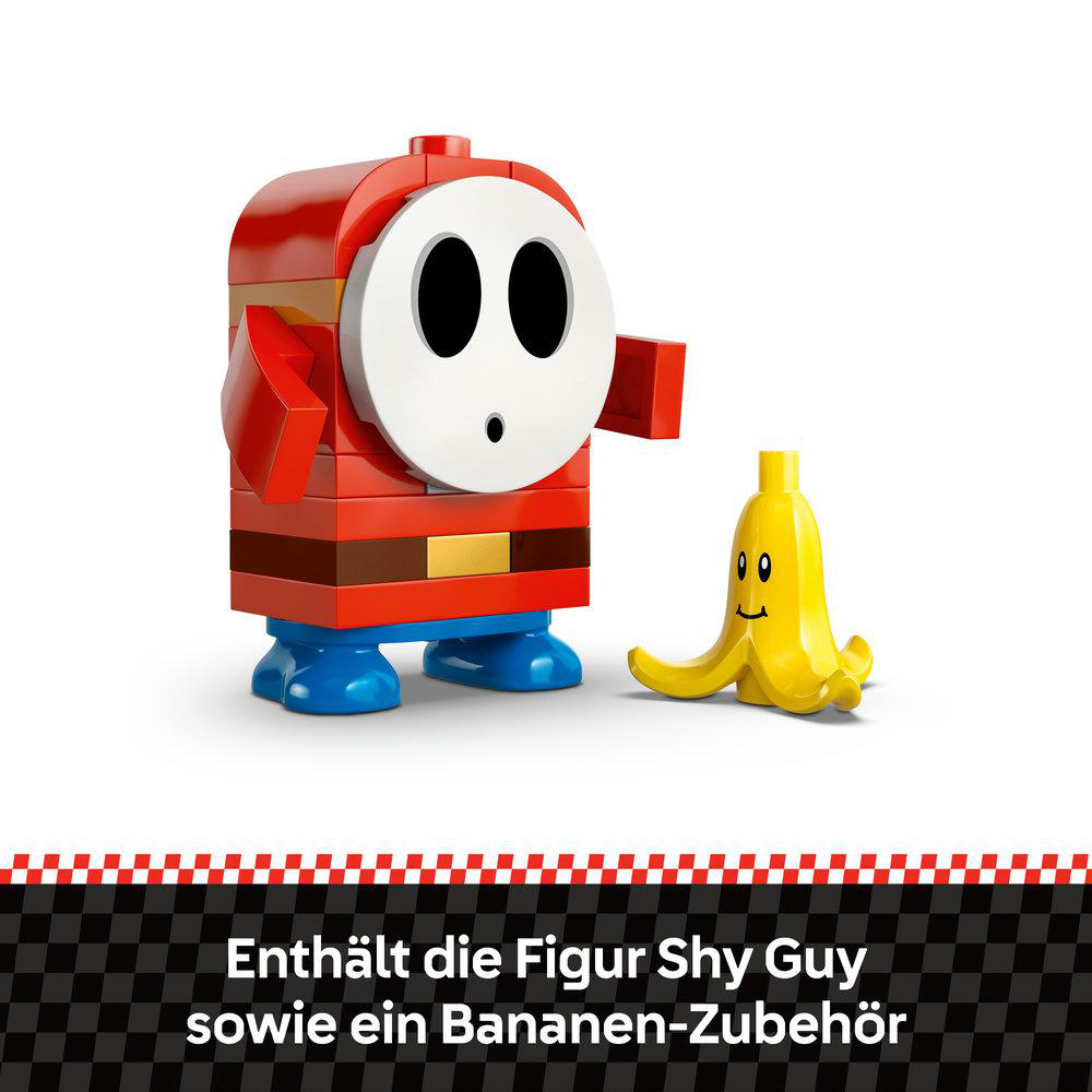 Eine Shy Guy Figur, rot und weiß, mit Bananenzubehör. Die Figur besteht aus Blöcken mit weißer Maske und zwei Augen.