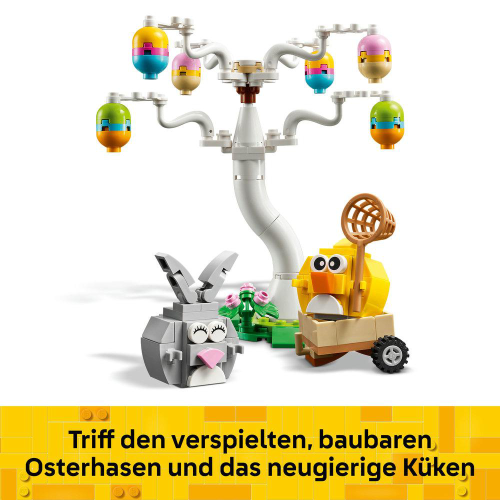 Eine Lego-Osterszene mit einem Hasen, einem Küken in einem Wagen und einem Baum mit bunten, eiförmigen Ornamenten. Weißer Hintergrund.