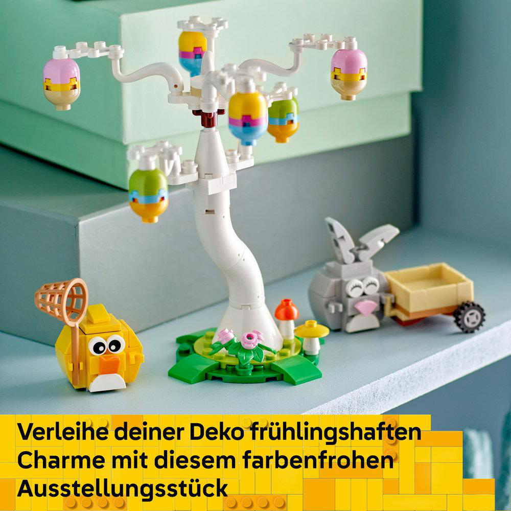 Ein Lego-Set mit einem Baum mit bunten eiförmigen Ornamenten, einem gelben Vogel, einem grauen Hasen mit Wagen und einem Pilz.