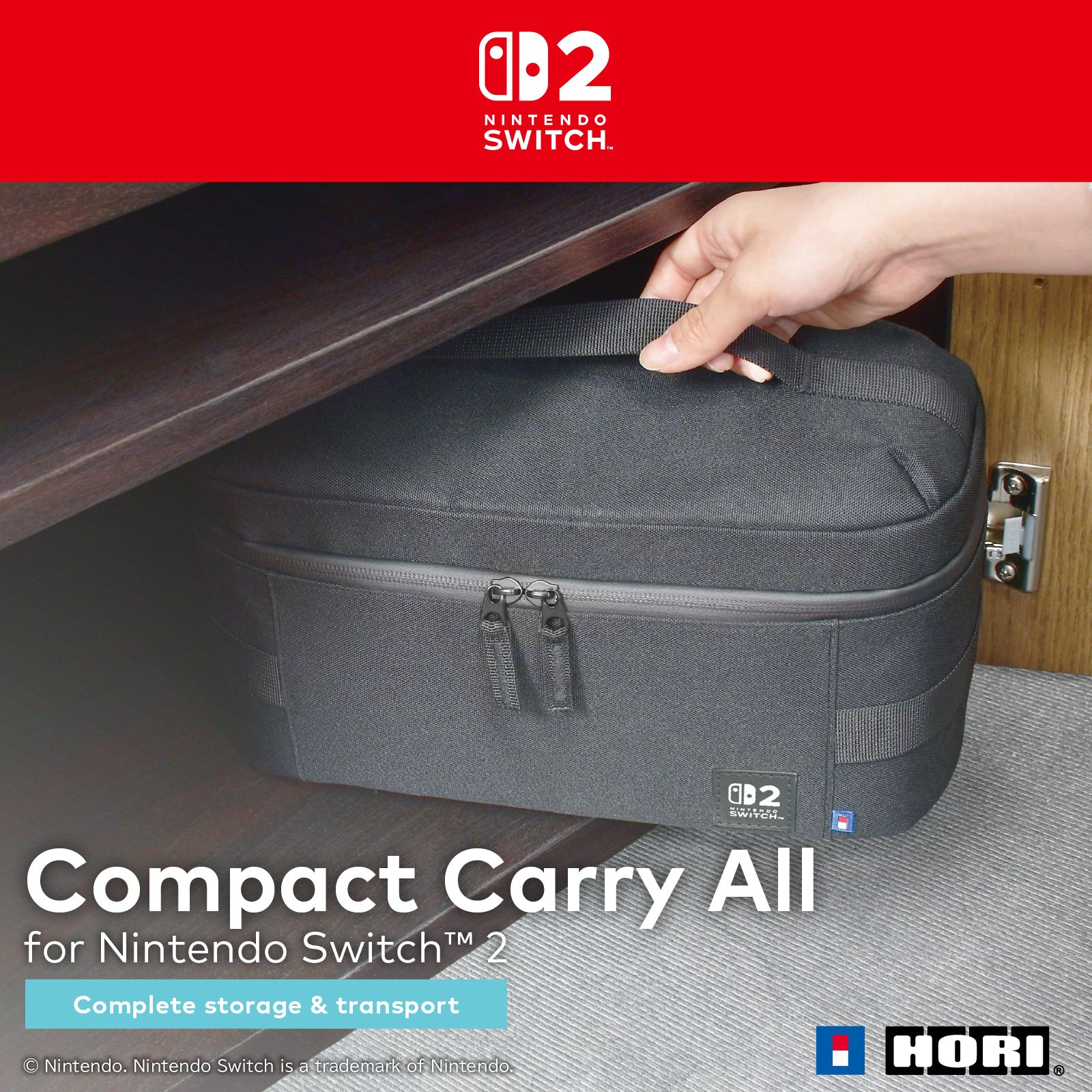 Eine schwarze Nintendo Switch-Tragetasche wird in einen Holzschrank gelegt. Eine Hand hält den Griff.
