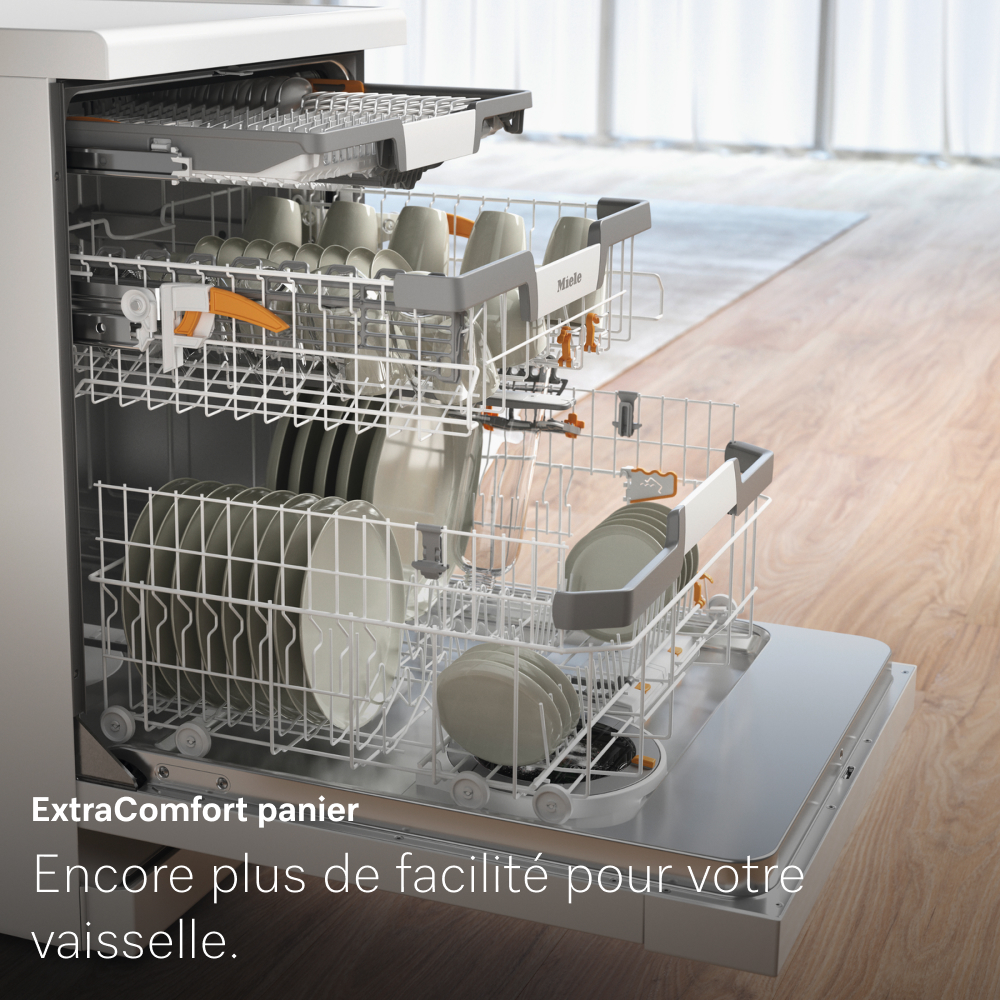 Lave-vaisselle ouvert, chargé d'assiettes, tasses et ustensiles. Intérieur avec plusieurs paniers. Texte en bas: ExtraComfort panier.