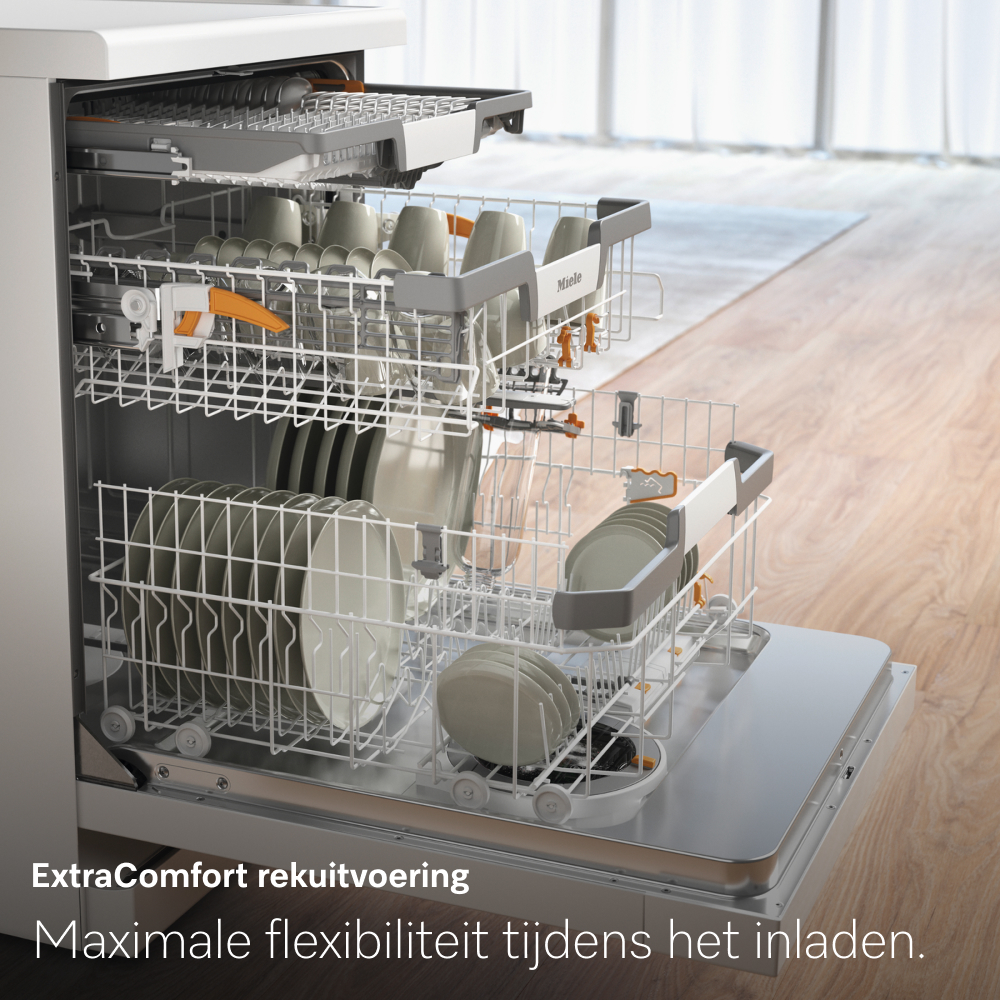 Dishwasher with open door. Plates, cups, and utensils are loaded inside. The machine is white, and the background shows a wooden floor.