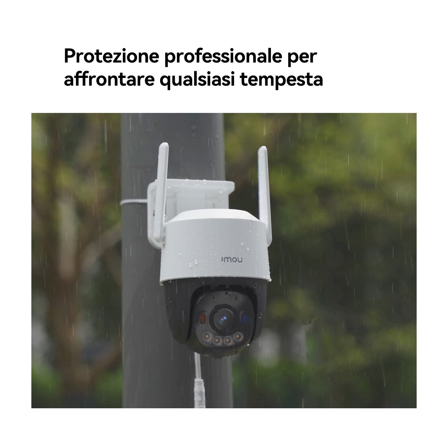 Una telecamera di sicurezza bianca e nera con antenne è montata su un palo. Sta piovendo. La telecamera ha il marchio IMOU.