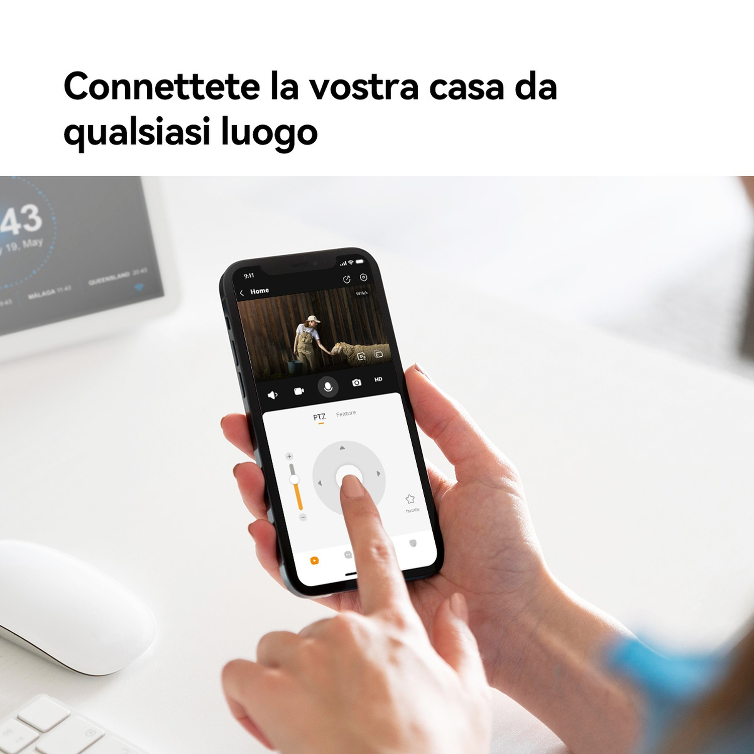 Una persona usa uno smartphone per controllare una telecamera di sicurezza. Il telefono mostra un feed in diretta di una persona in un campo.