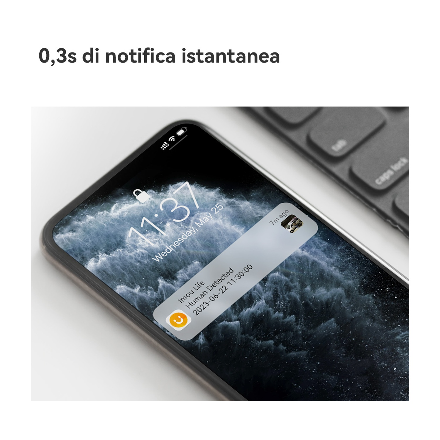 Uno smartphone mostra una notifica di rilevamento umano, con ora e data. Una tastiera è sullo sfondo.