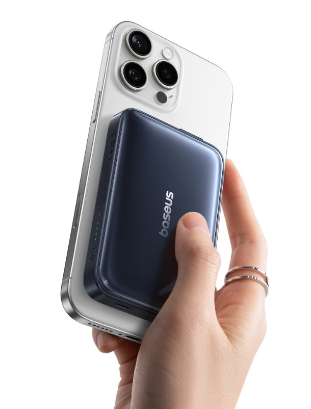 Bir el, üzerinde koyu mavi bir Baseus powerbank bulunan bir telefonu tutuyor. Telefon gümüş rengi, powerbank koyu mavi.