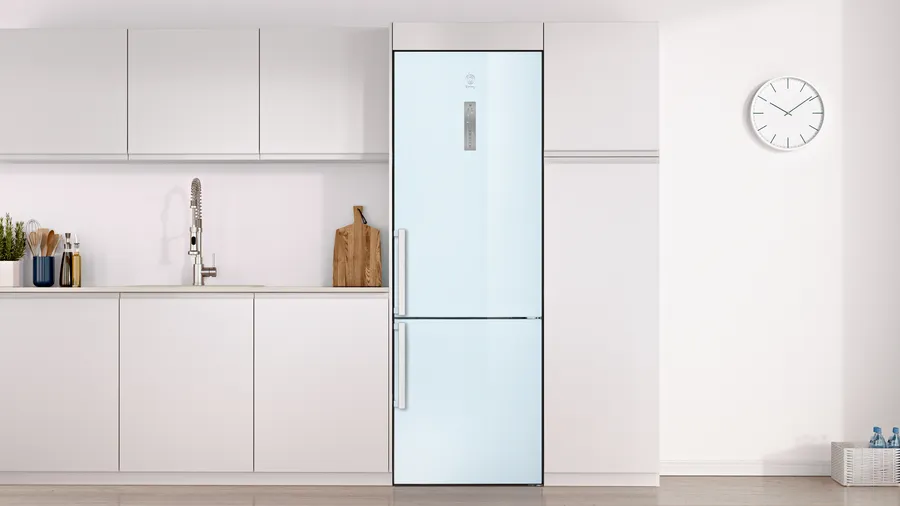 Una cocina moderna con armarios blancos, un refrigerador azul claro y una pared blanca con un reloj. Un fregadero y una tabla de cortar de madera.