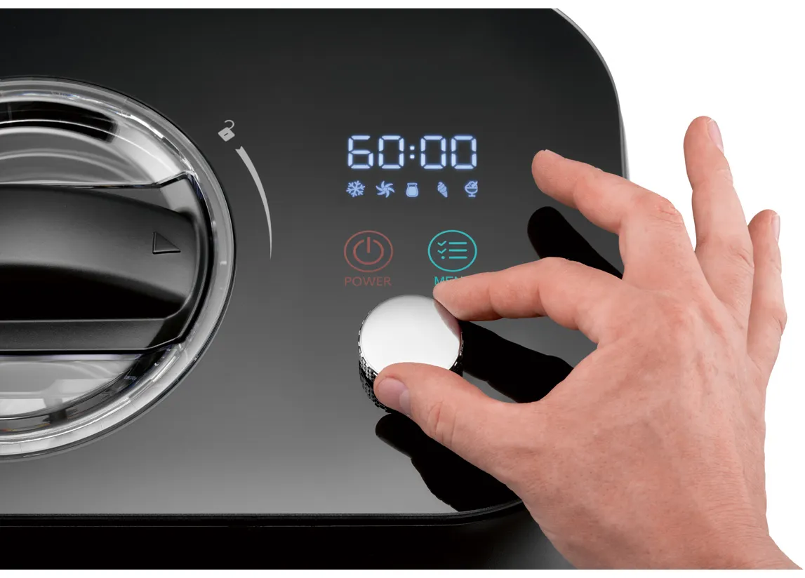 Una mano gira una manopola su un elettrodomestico nero. Il display mostra 60:00. I pulsanti Power e Menu sono visibili.