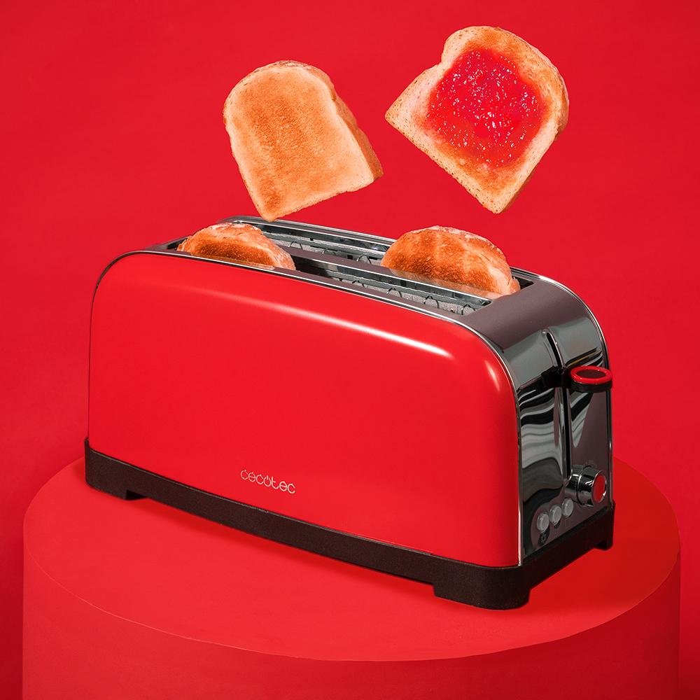 Una tostadora roja con dos rebanadas de pan dentro y dos rebanadas de tostadas con mermelada encima sobre una superficie roja.