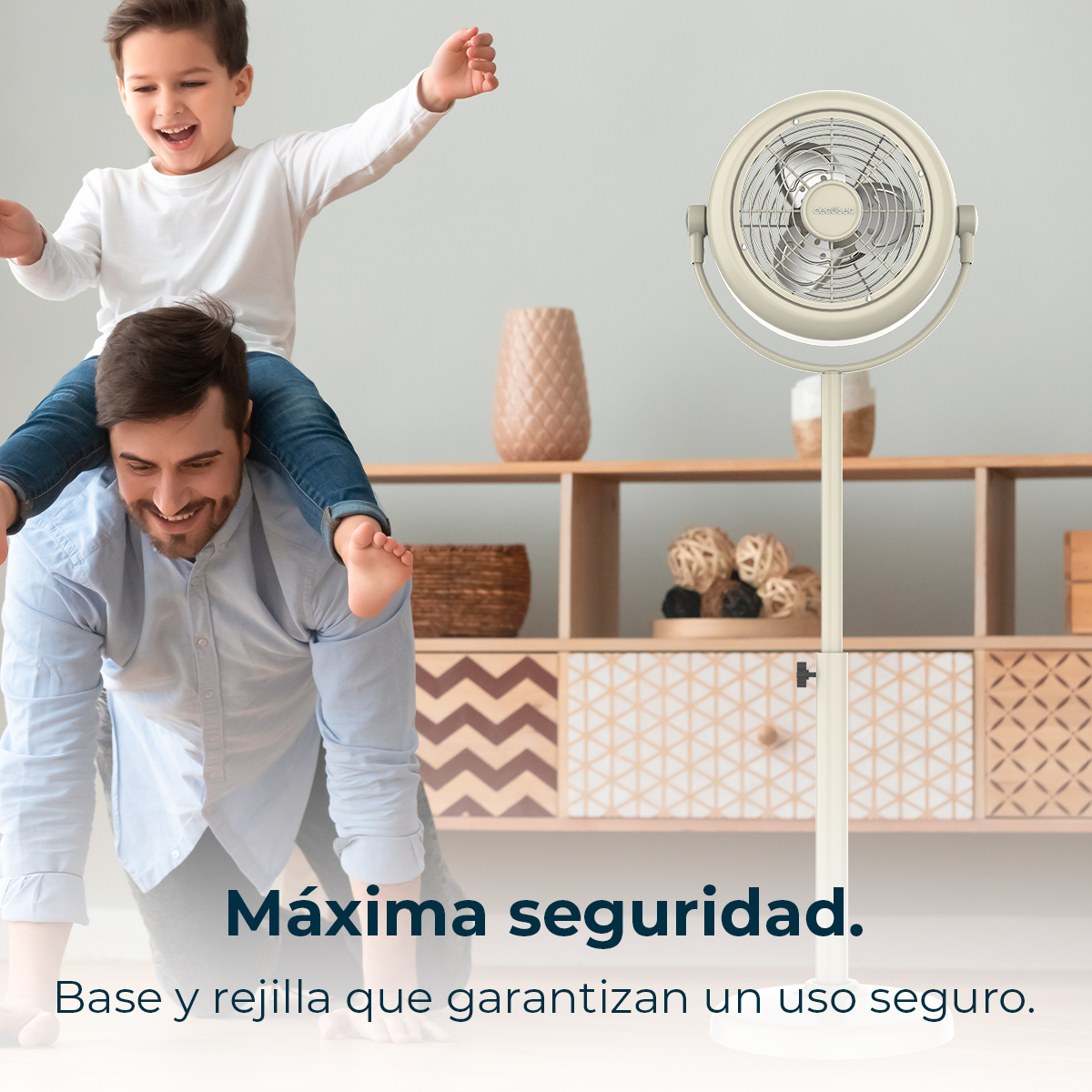 Un hombre lleva a un niño a la espalda, sonríen. Un ventilador beige delante de un mueble de madera. Texto: Máxima seguridad.
