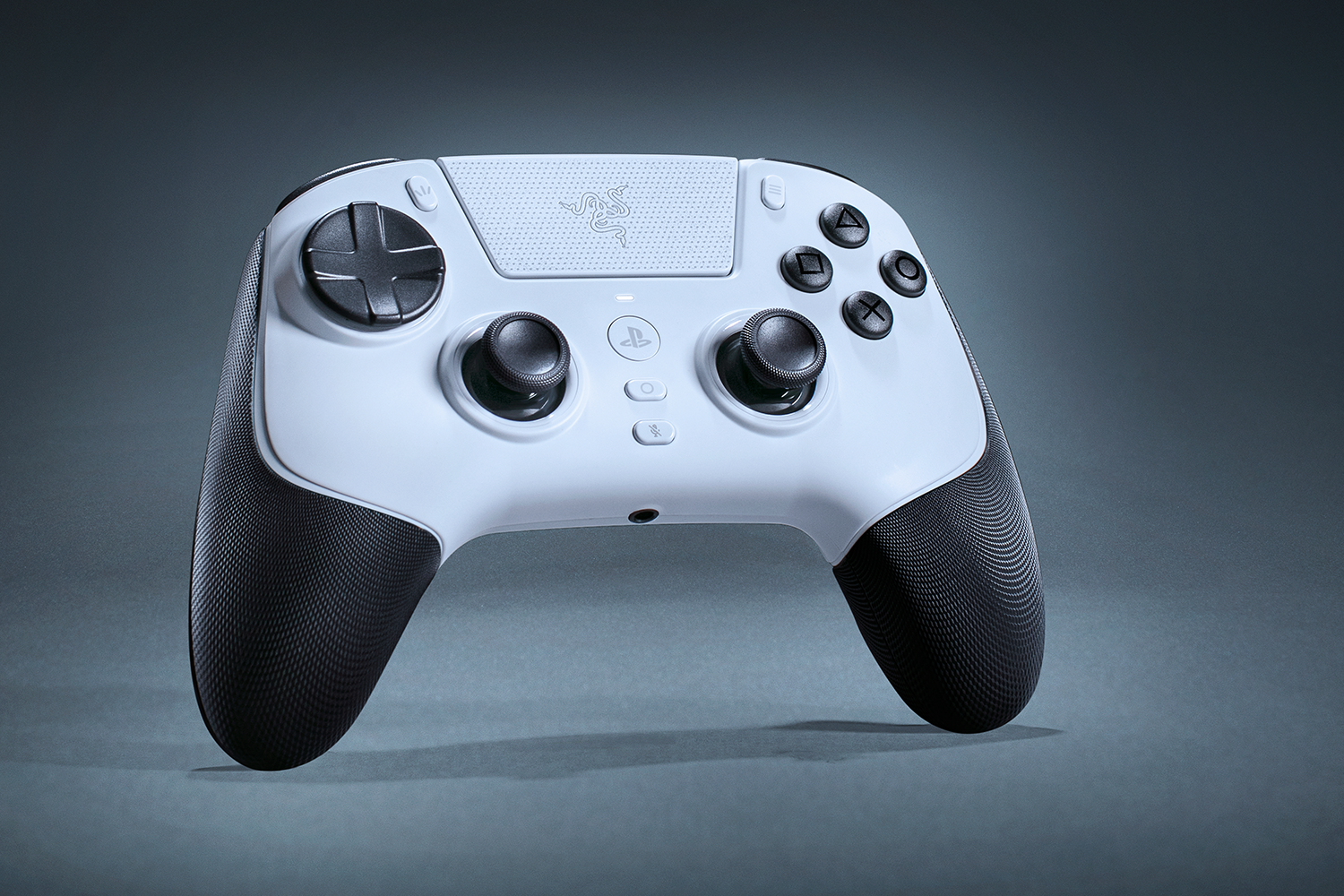 Un mando de juegos blanco y negro está centrado. Tiene botones, joysticks y agarres texturizados sobre un fondo gris.