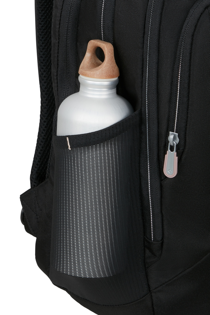 Srebrna butelka na wodę z beżową nakrętką znajduje się w czarnej siatkowej kieszeni bocznej plecaka.