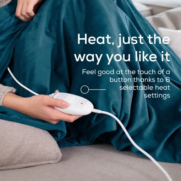 Una persona tiene in mano un controller bianco collegato a una coperta verde acqua. Il testo recita: Calore, come piace a te.