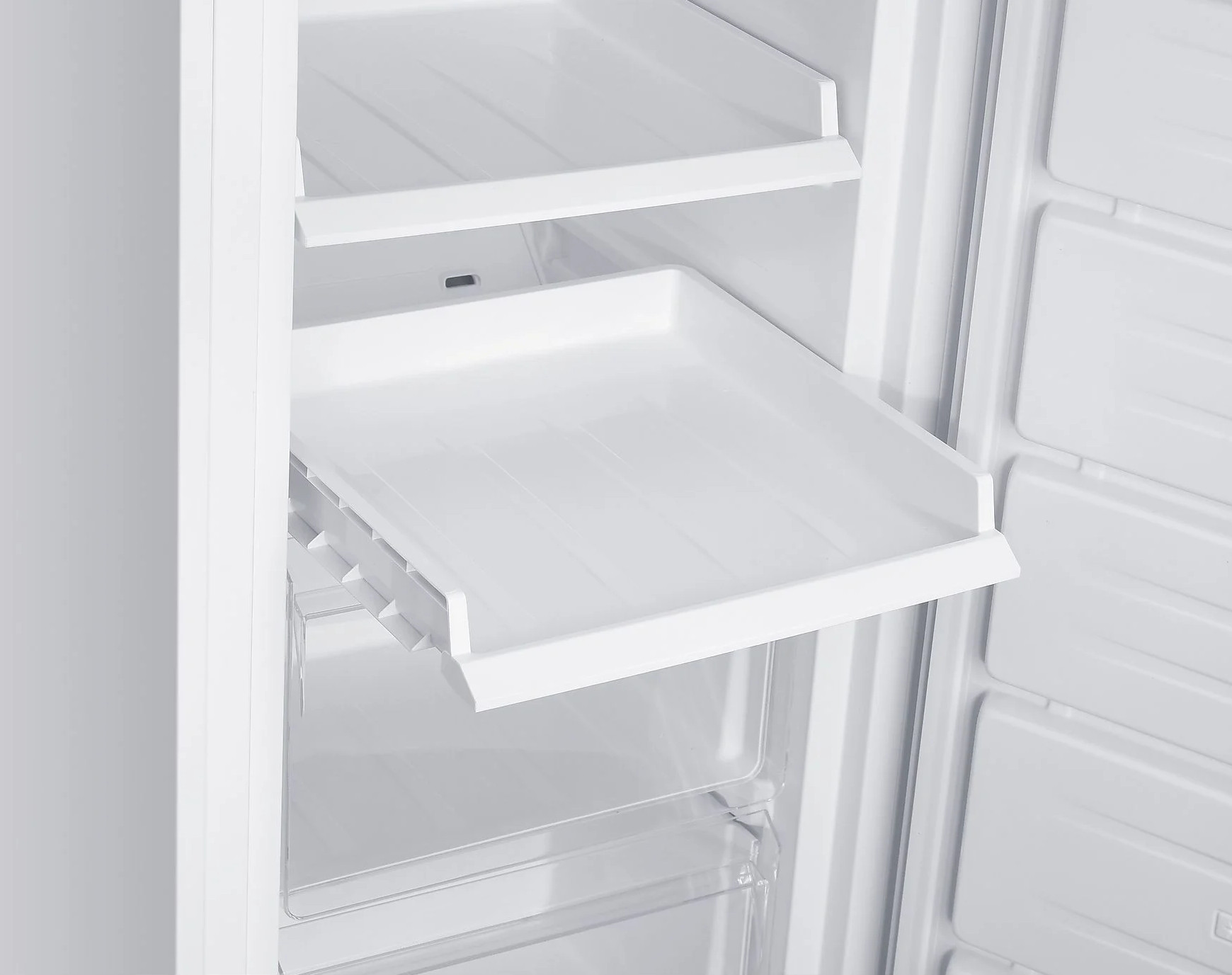 Otwarty biały wnętrze lodówki z półkami i wysuwaną tacą. Czyste, puste i dobrze oświetlone. Drzwi są uchylone.