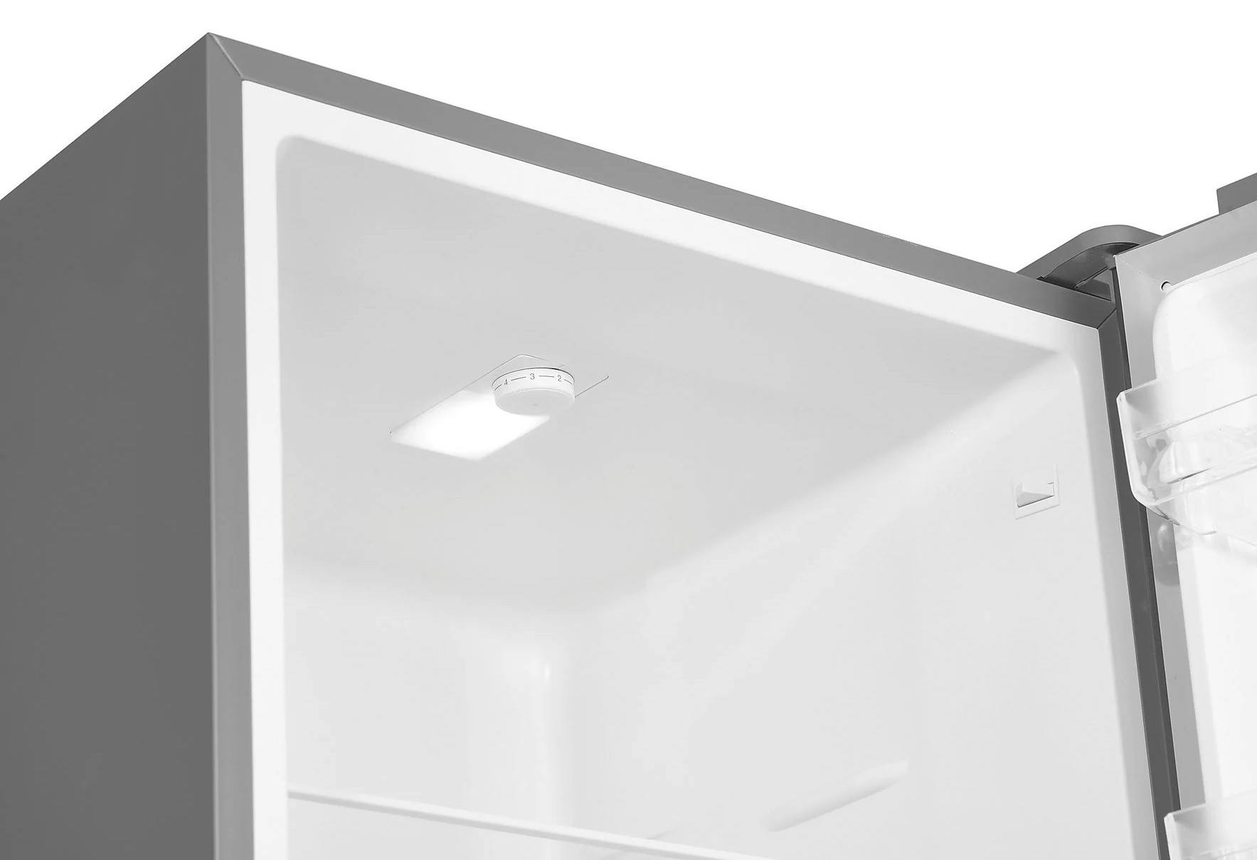 Wnętrze lodówki, widoczne białe wnętrze. Obecne jest światło i pokrętło regulacji temperatury. Rama jest szara.