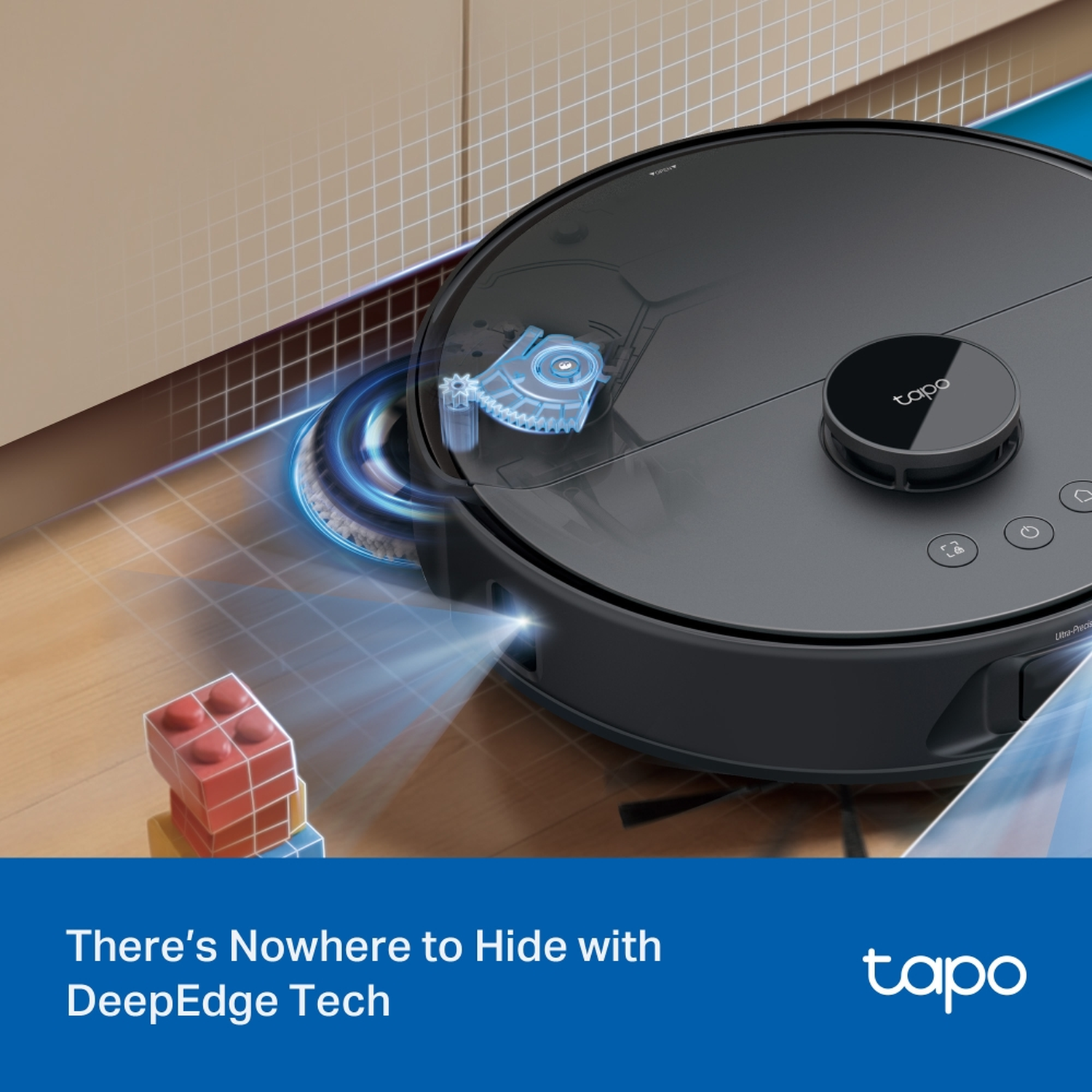 A black Tapo robot vacuum cleaner on a wooden floor, with a pile of toy blocks in the foreground.