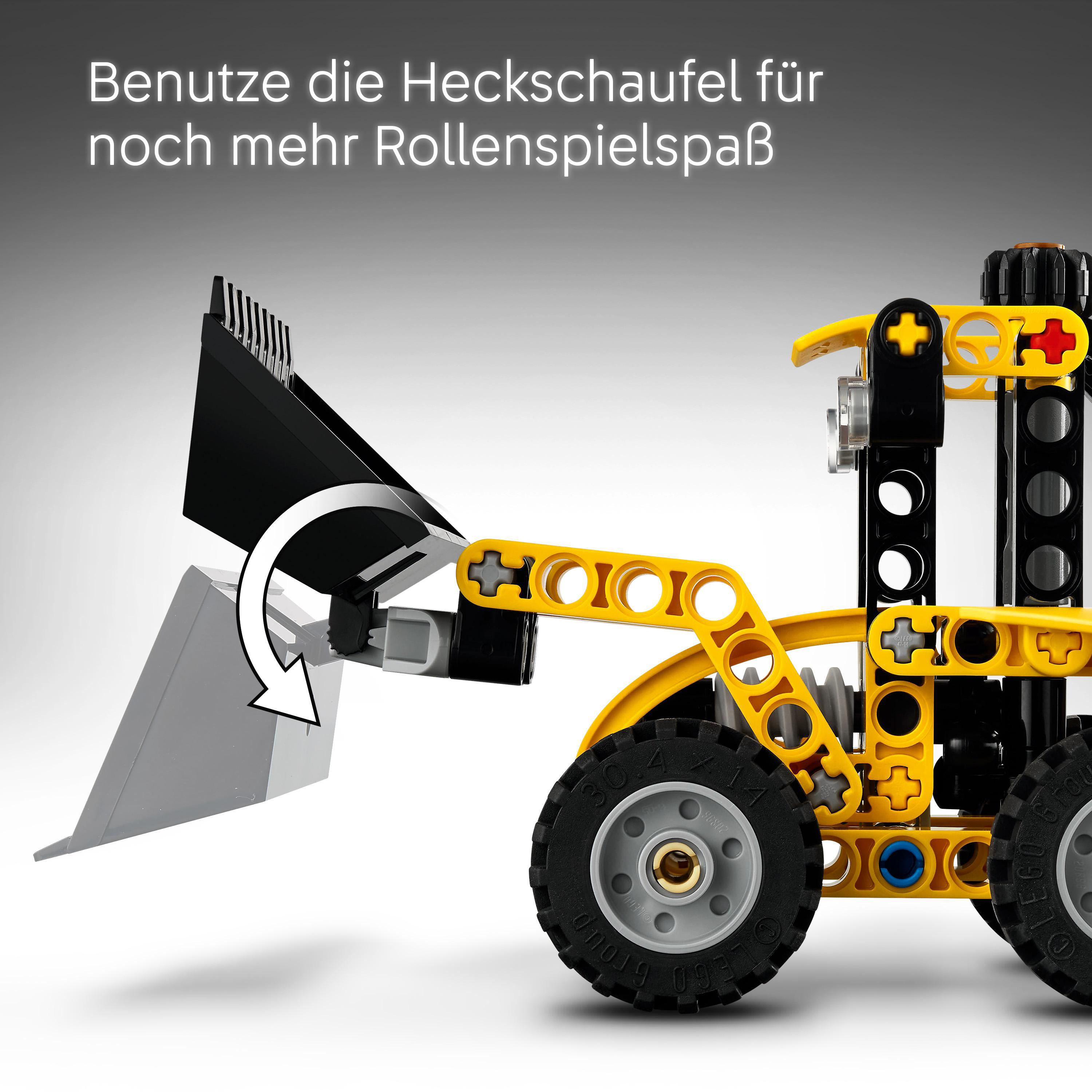 Gelbes Lego-Baufahrzeug mit gesenkter schwarzer und grauer Schaufel. Pfeil zeigt Bewegung.